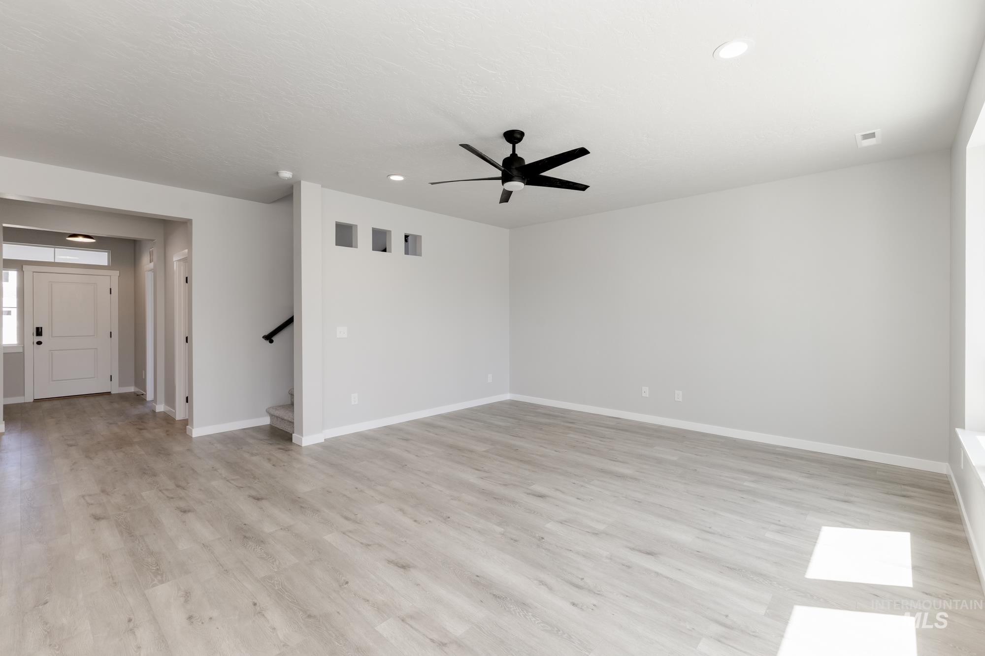 Spare room featuring recessed lighting, stairs, light wood finished floors, and ceiling fan