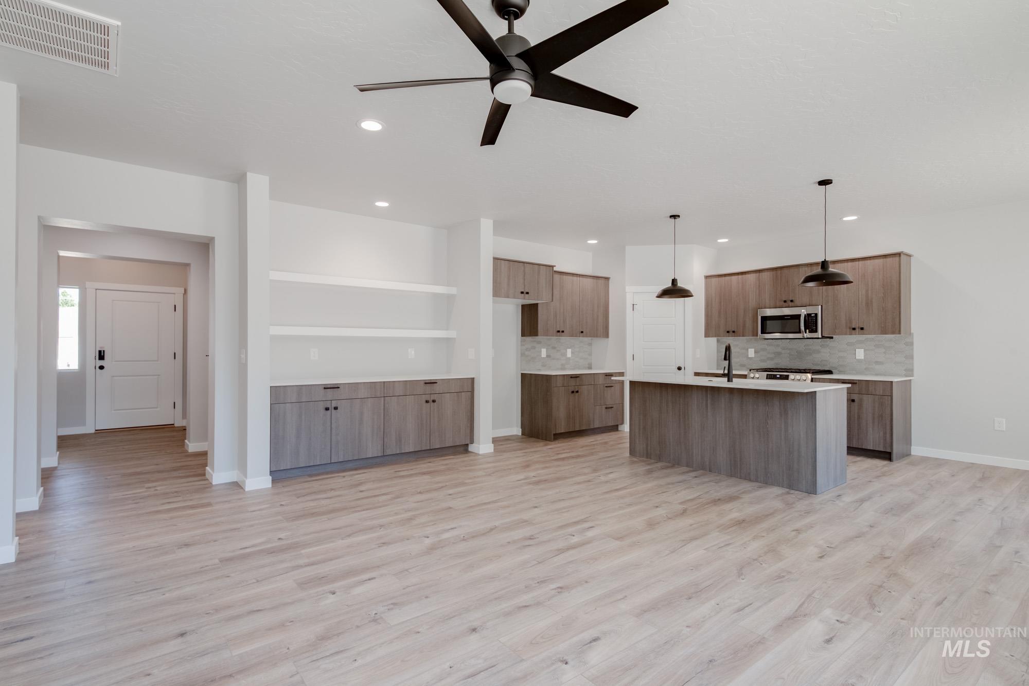 Kitchen with stainless steel microwave, recessed lighting, tasteful backsplash, a ceiling fan, and light wood-style floors