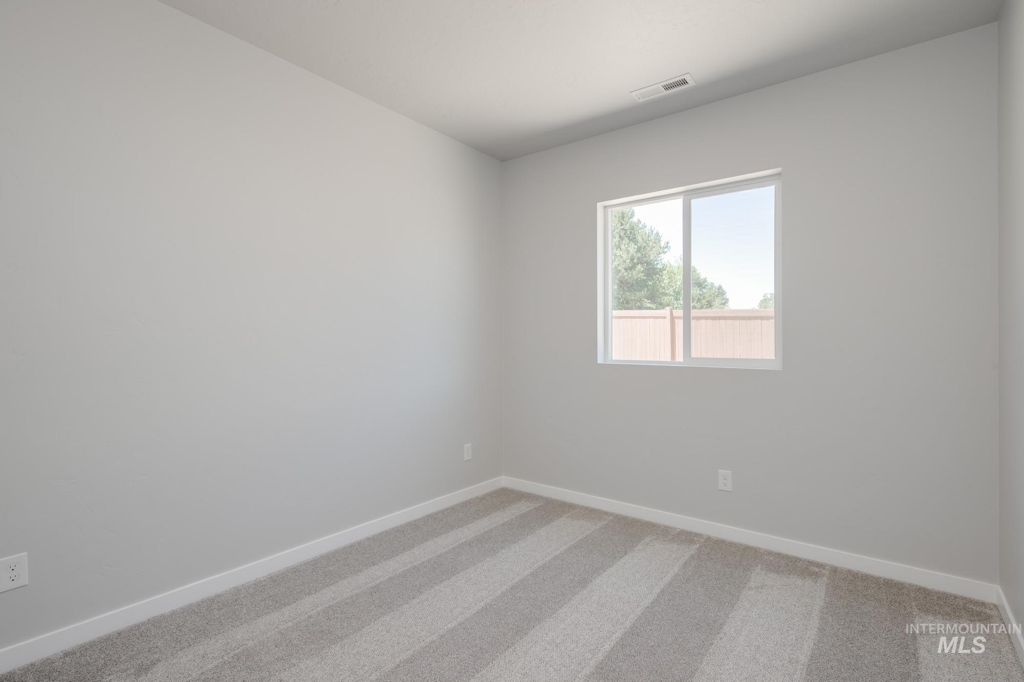 Spare room featuring baseboards and light colored carpet