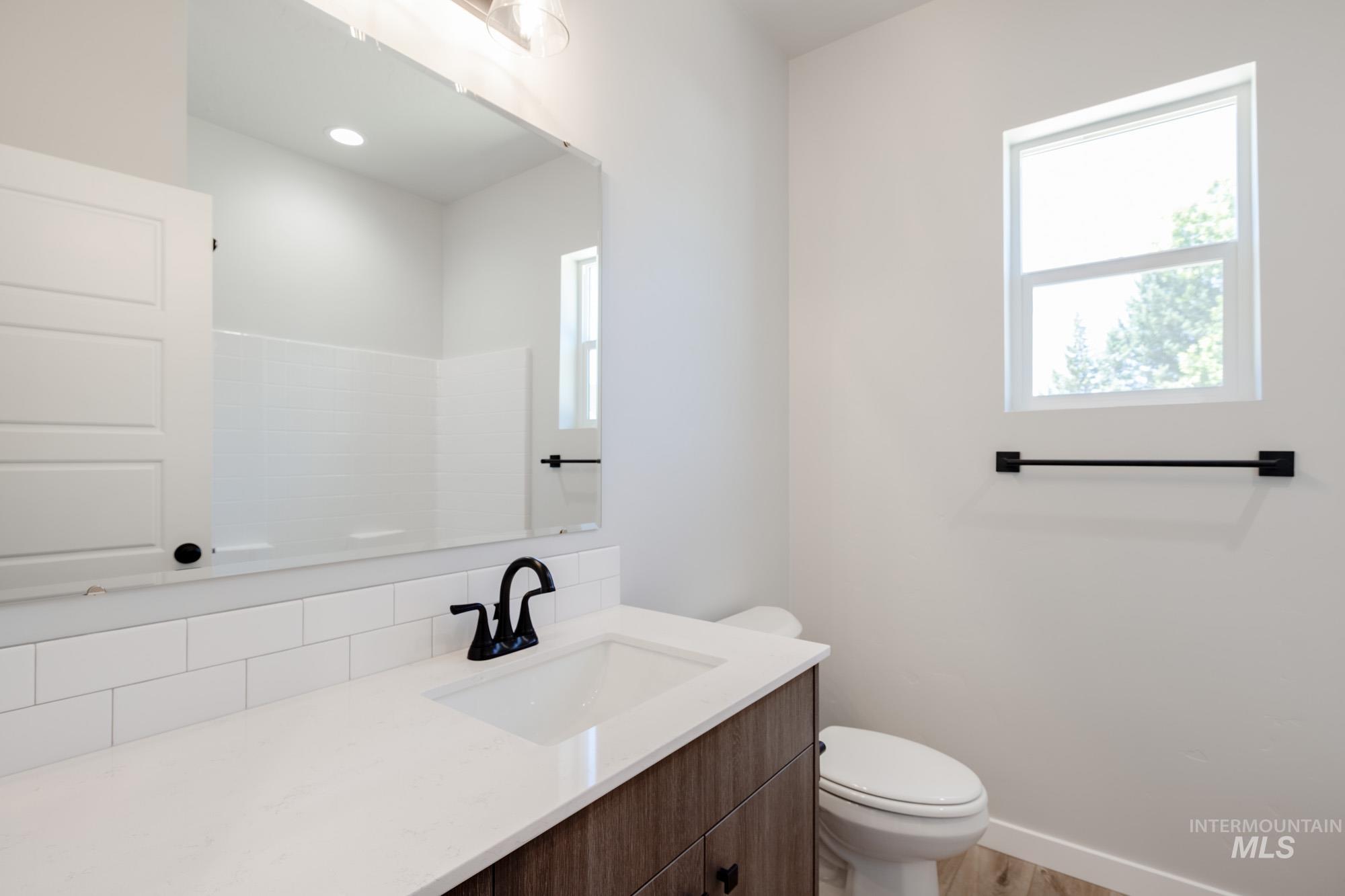 Bathroom with vanity, decorative backsplash, and wood finished floors