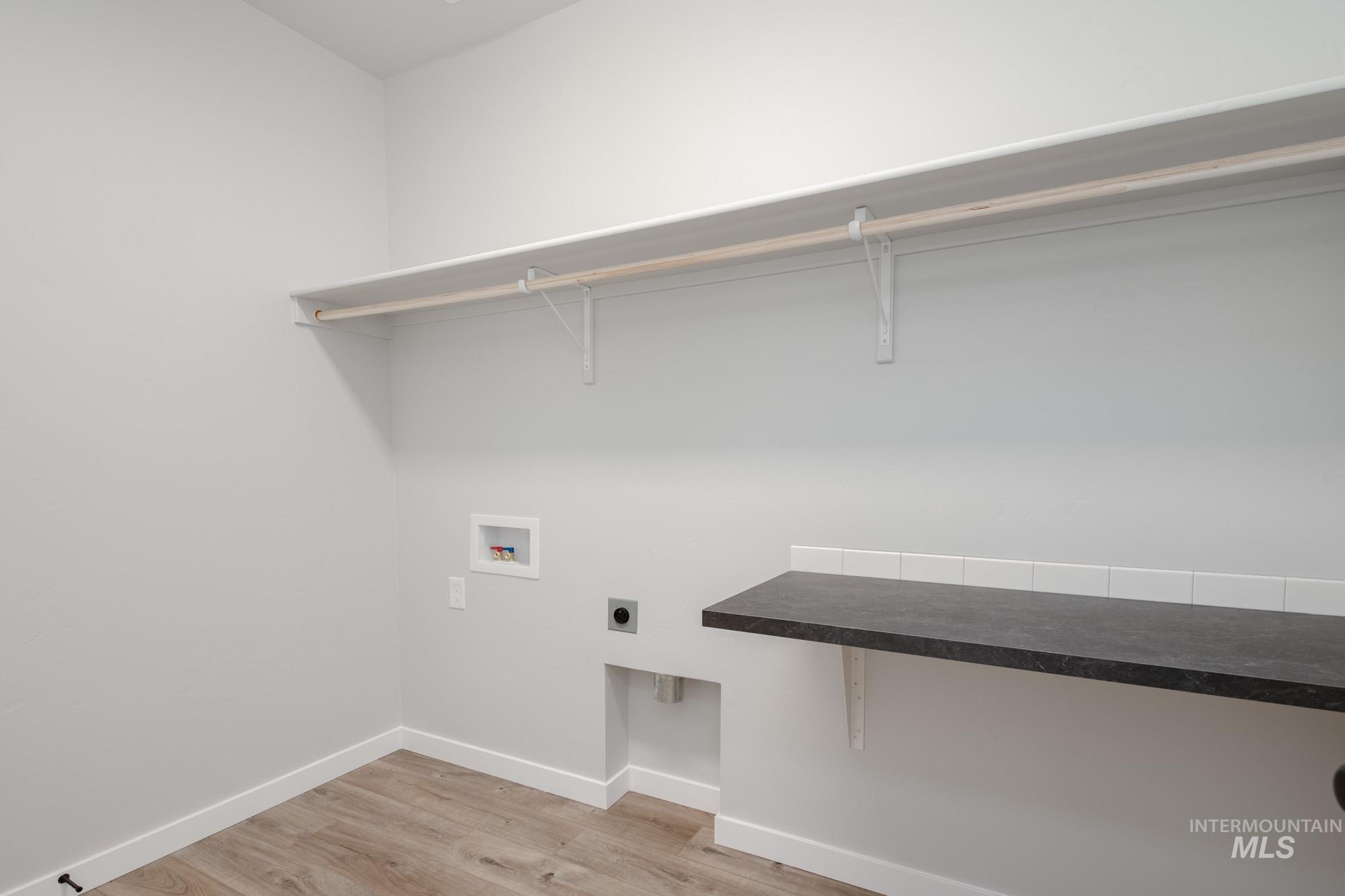 Laundry room featuring hookup for a washing machine, light wood-type flooring, and hookup for an electric dryer