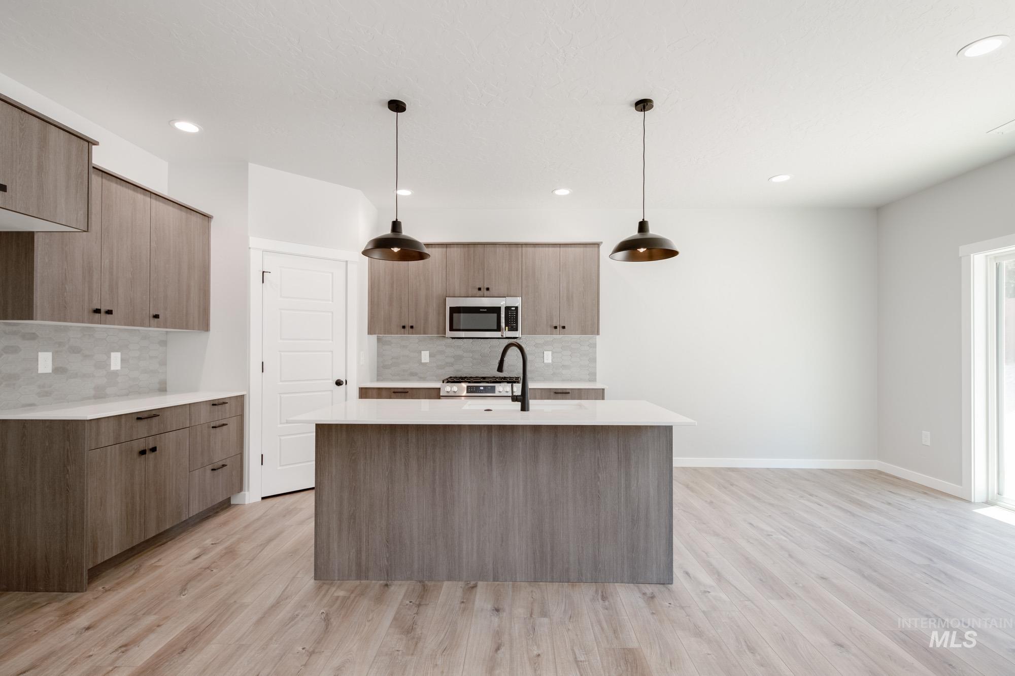 Kitchen featuring stainless steel appliances, tasteful backsplash, light countertops, modern cabinets, and recessed lighting