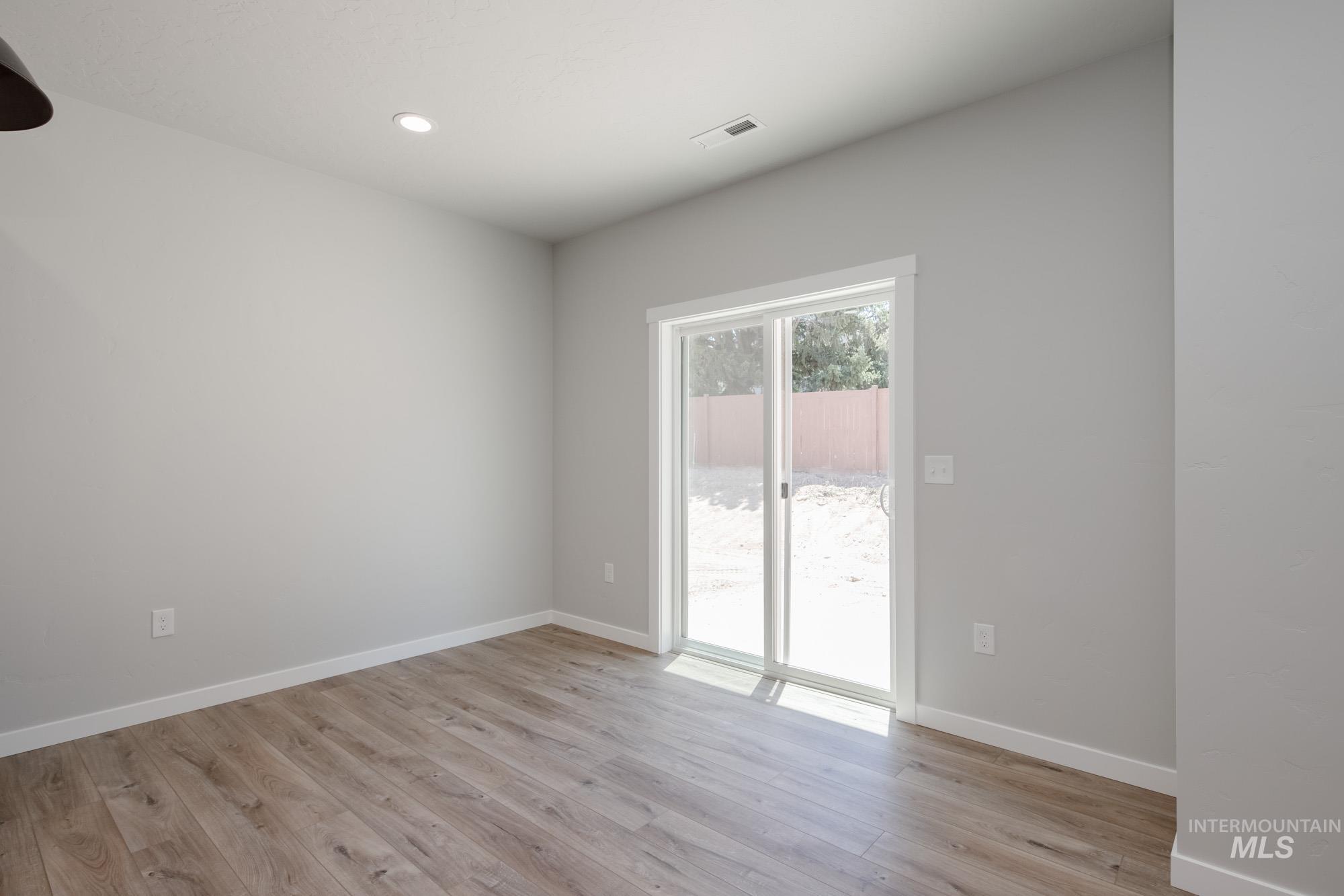 Empty room featuring light wood-style flooring and recessed lighting