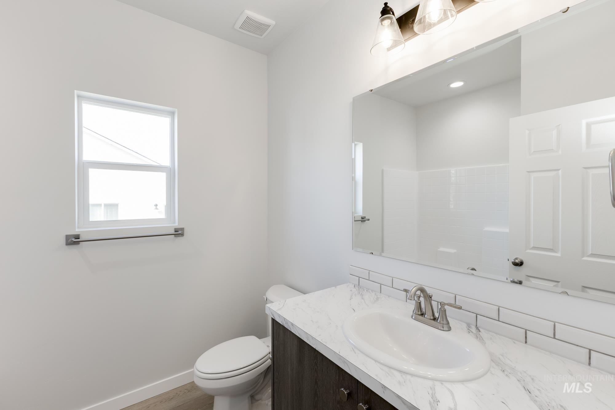 Bathroom featuring vanity, tasteful backsplash, and wood finished floors