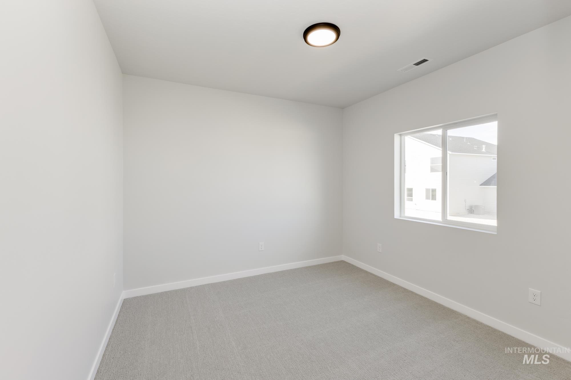 Carpeted spare room with baseboards