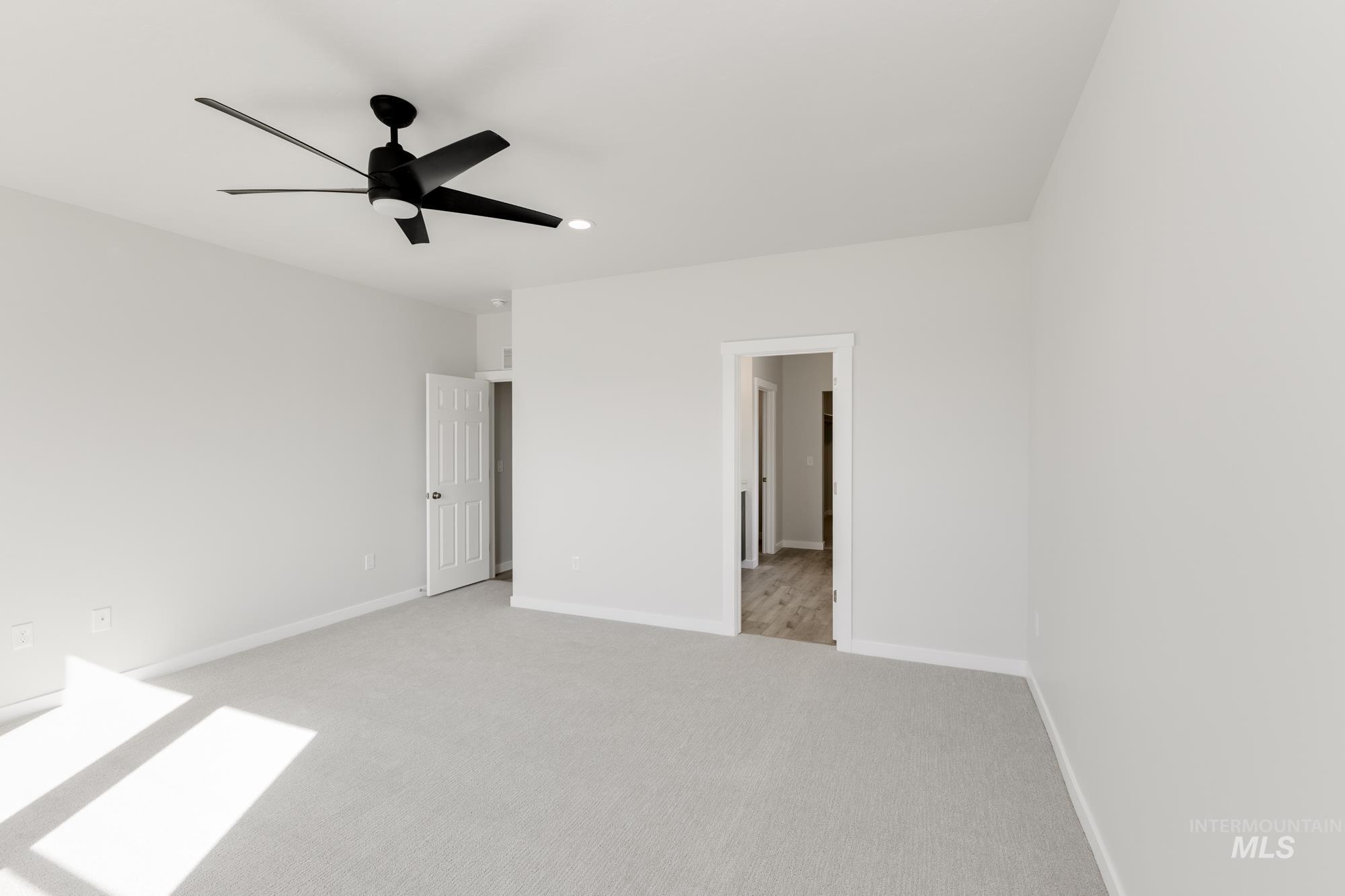 Unfurnished bedroom featuring light carpet and ceiling fan