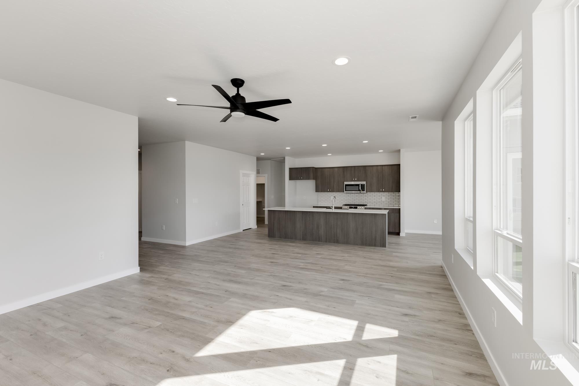 Unfurnished living room with recessed lighting, ceiling fan, and light wood finished floors