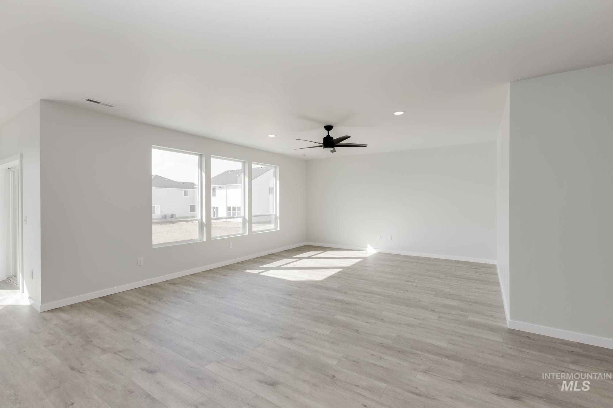 Spare room featuring light wood-type flooring, a ceiling fan, and recessed lighting