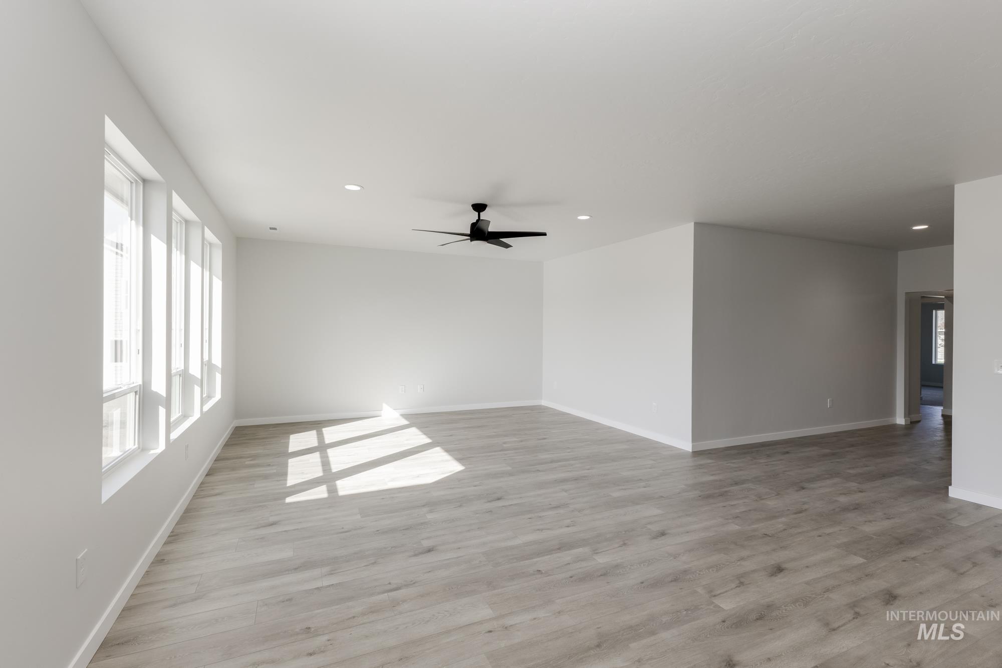 Unfurnished room featuring healthy amount of natural light, recessed lighting, light wood-style flooring, and a ceiling fan