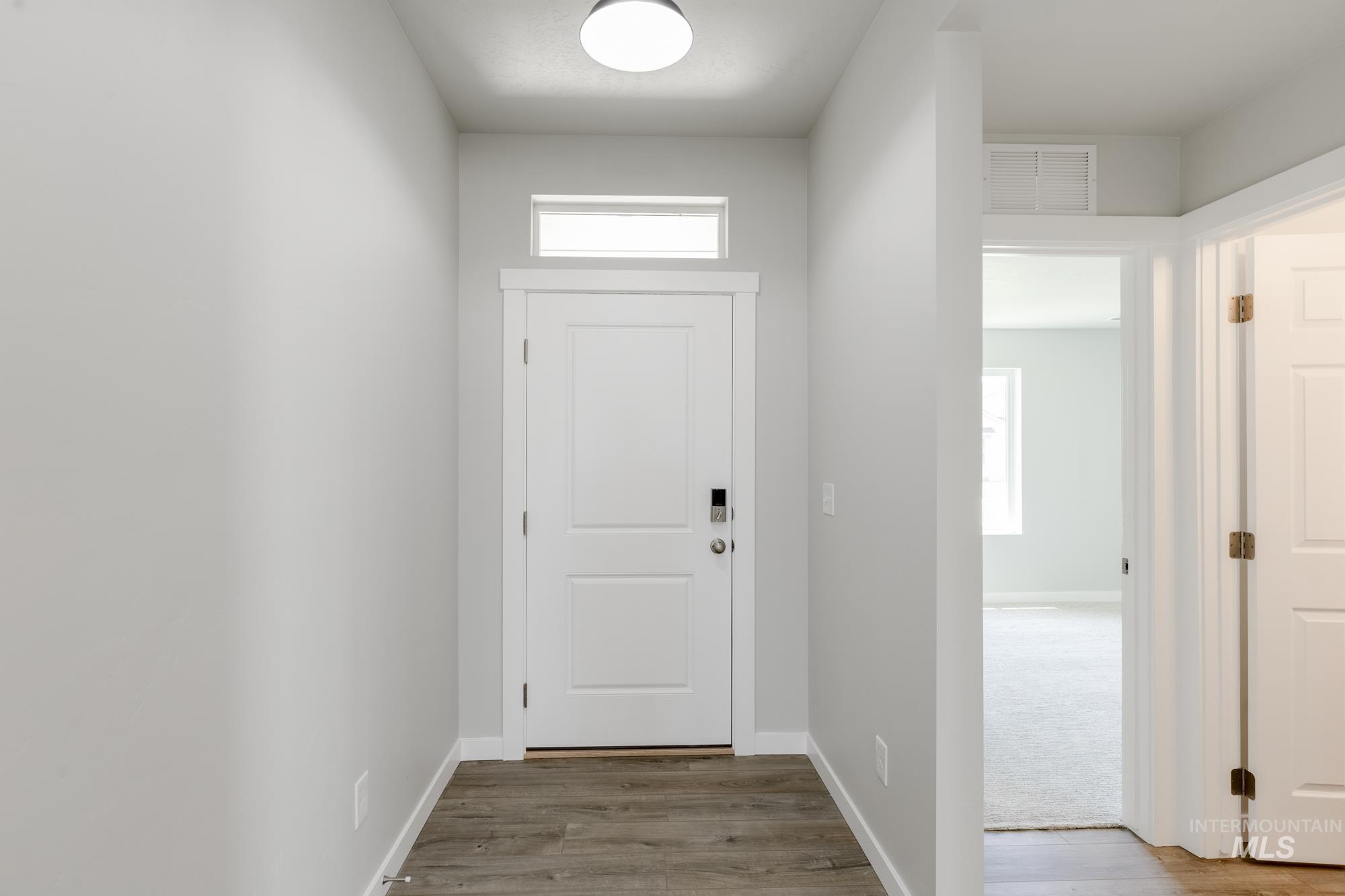 Doorway to outside with wood finished floors and healthy amount of natural light