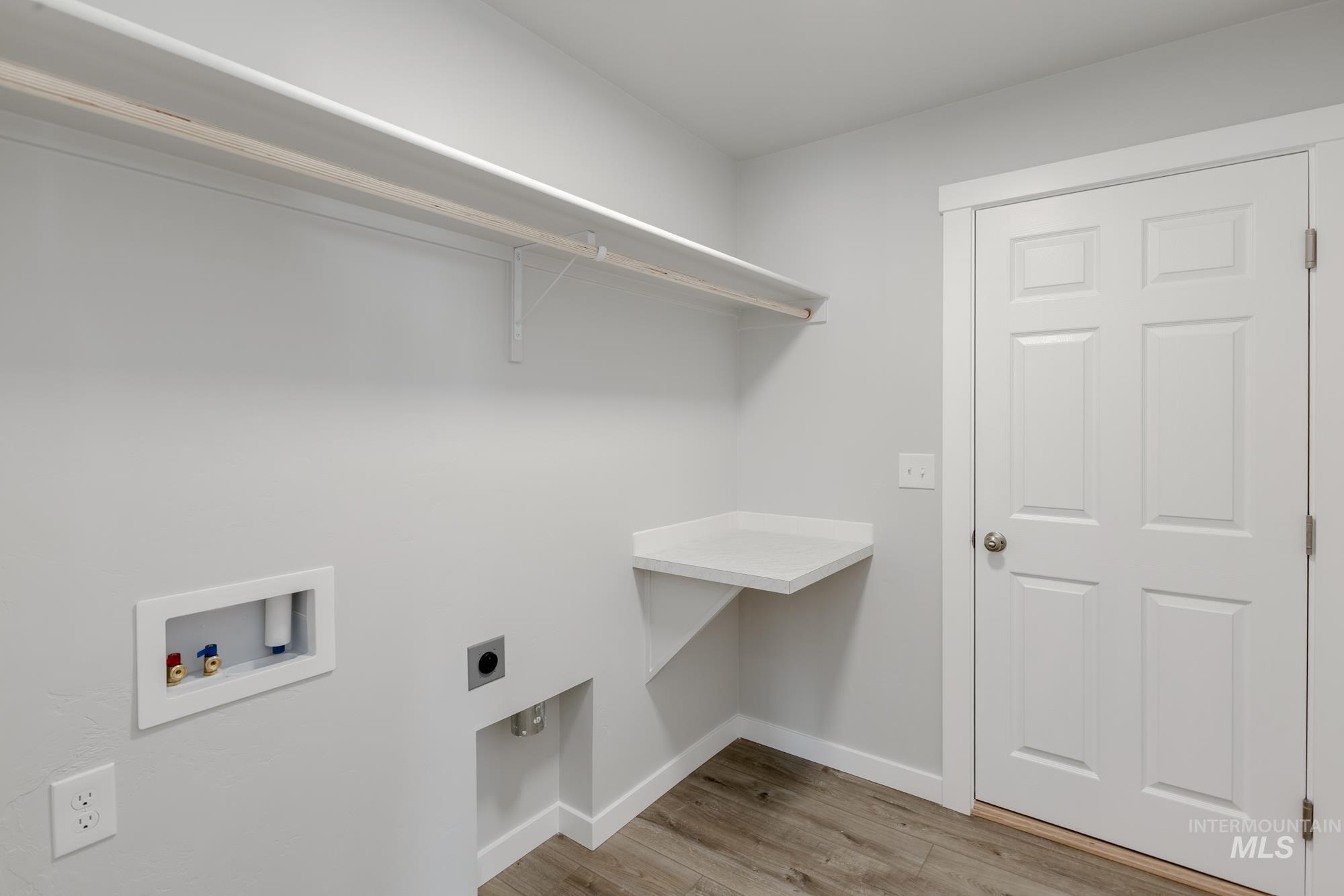 Laundry room with electric dryer hookup, hookup for a washing machine, and light wood-style floors