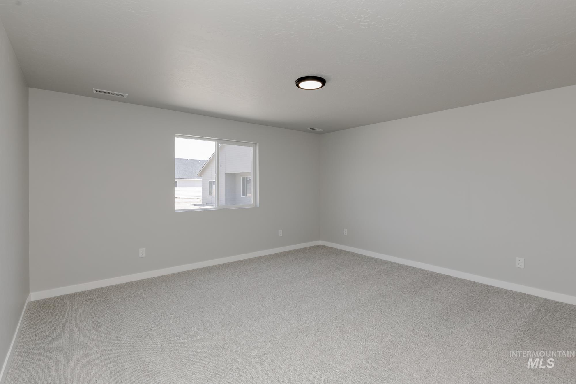 Spare room featuring carpet floors and baseboards