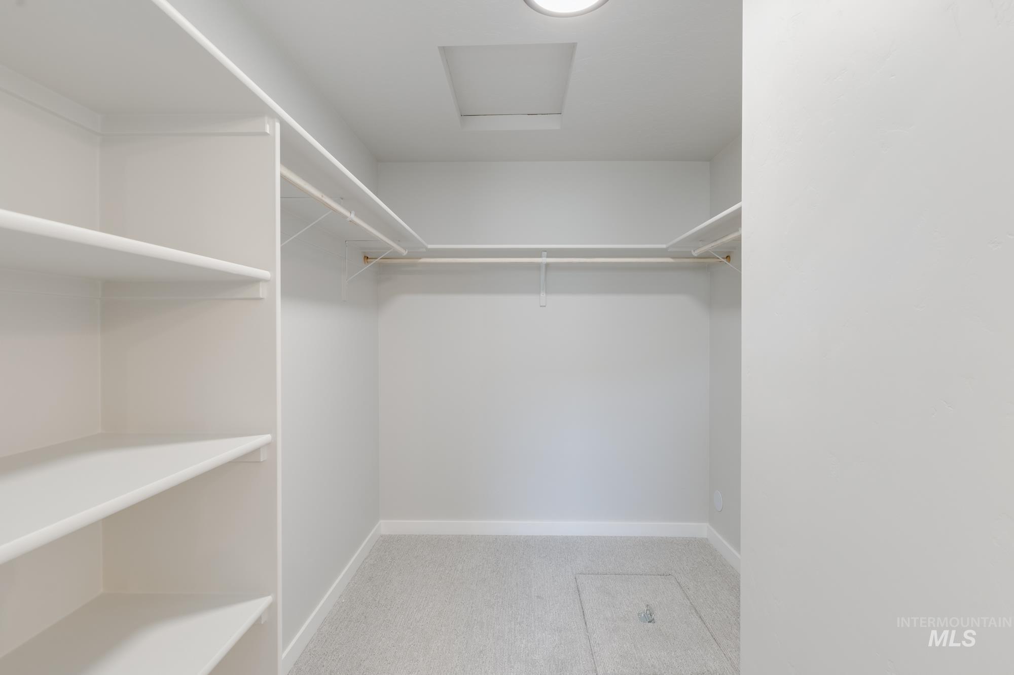 Spacious closet with carpet and attic access