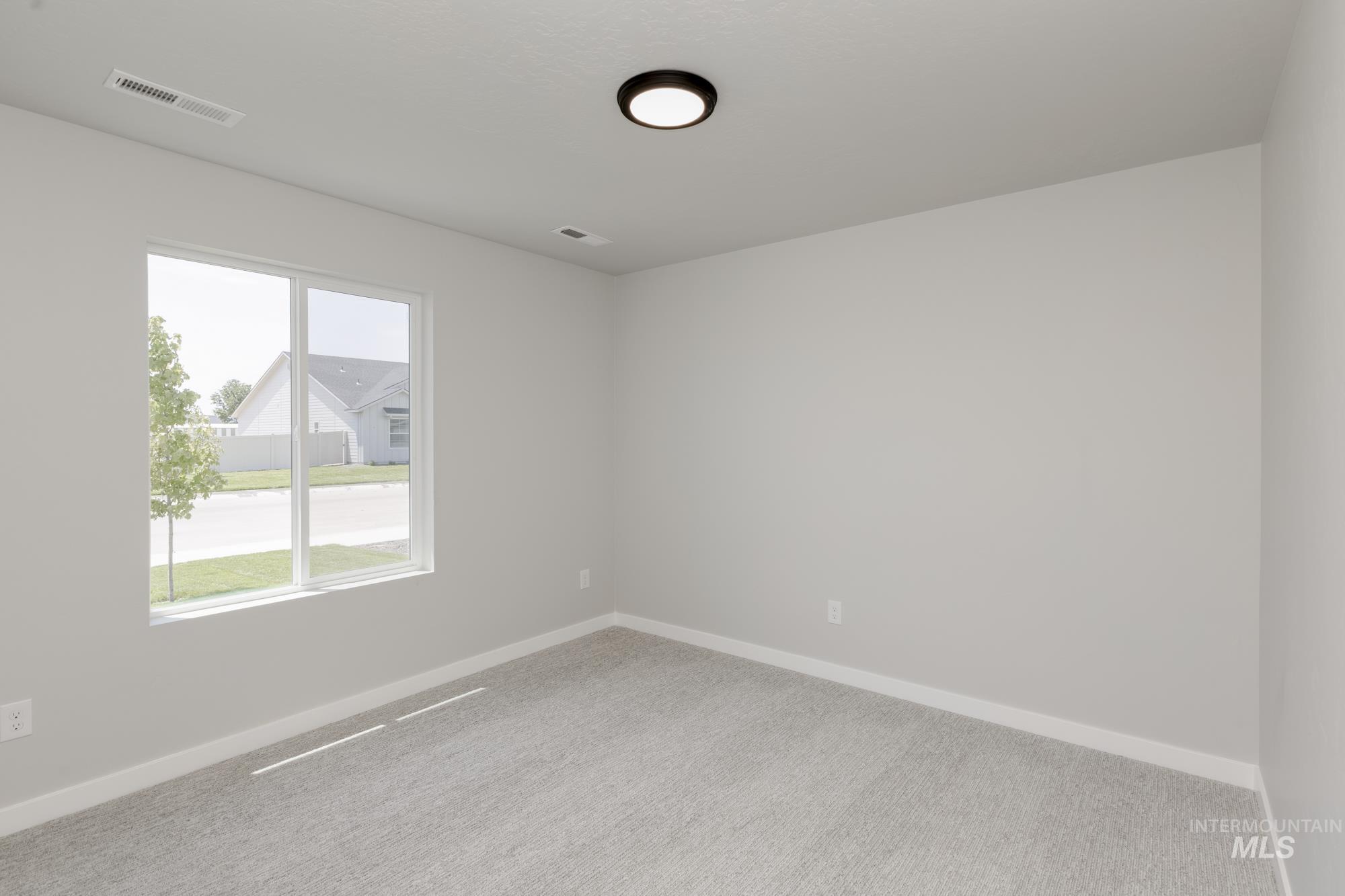 Carpeted spare room with baseboards