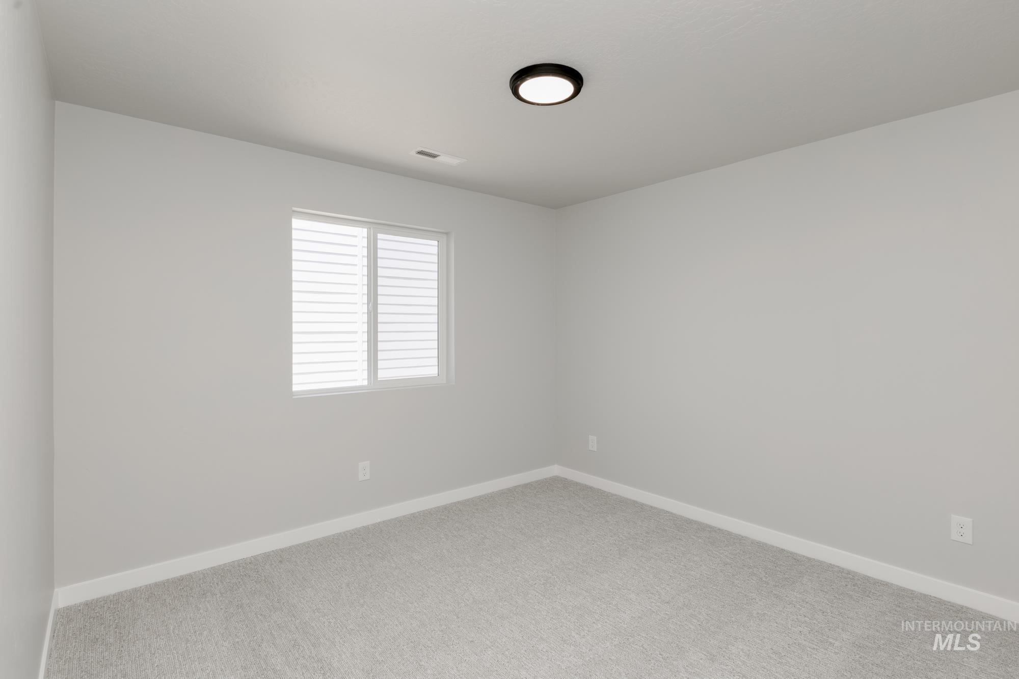 Carpeted spare room with baseboards