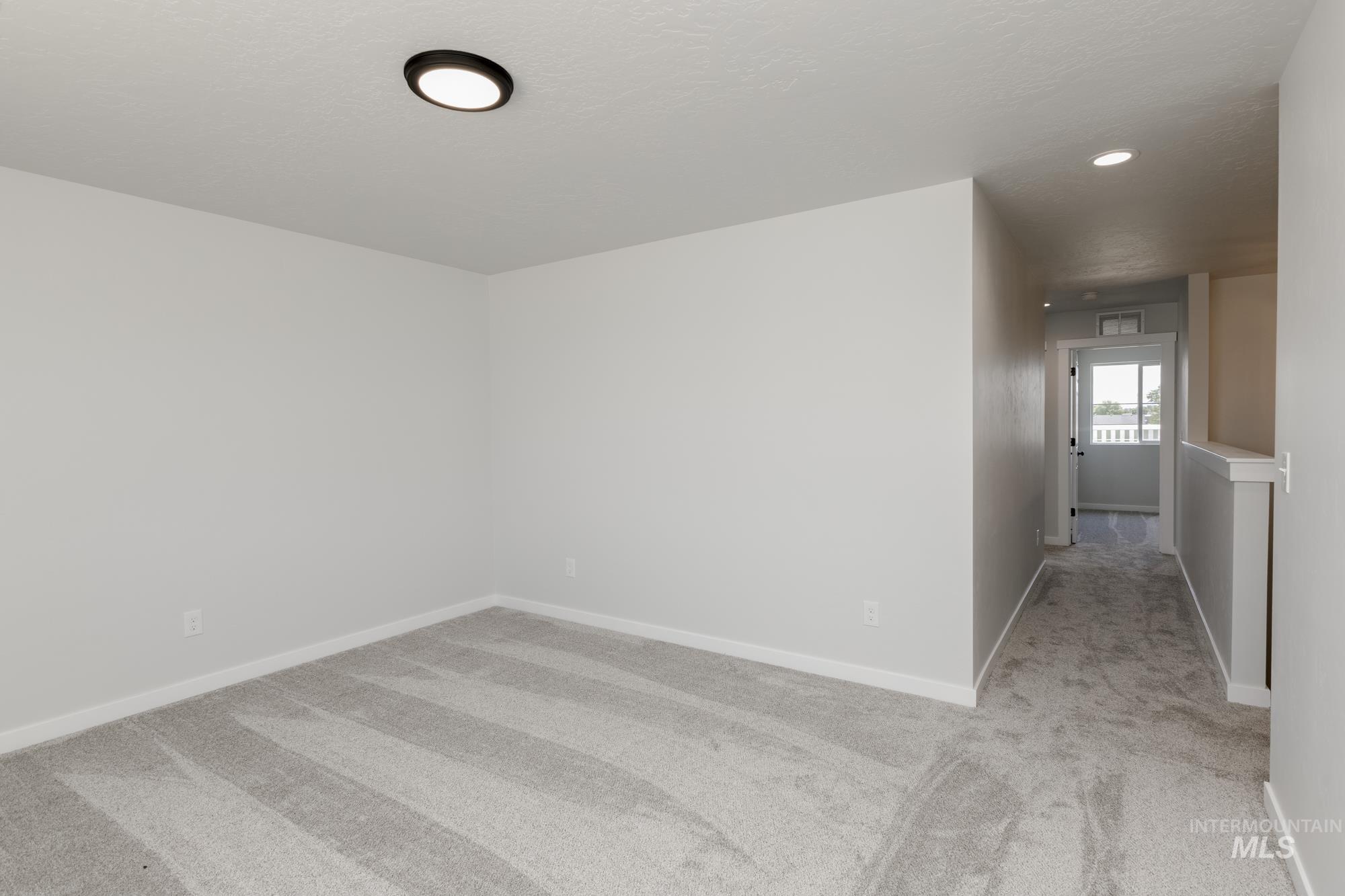 Empty room featuring light carpet and recessed lighting