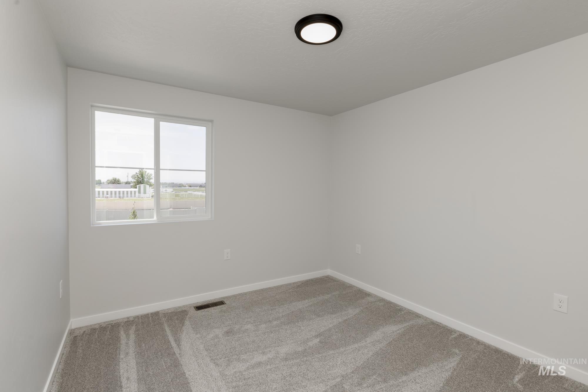Carpeted spare room with baseboards