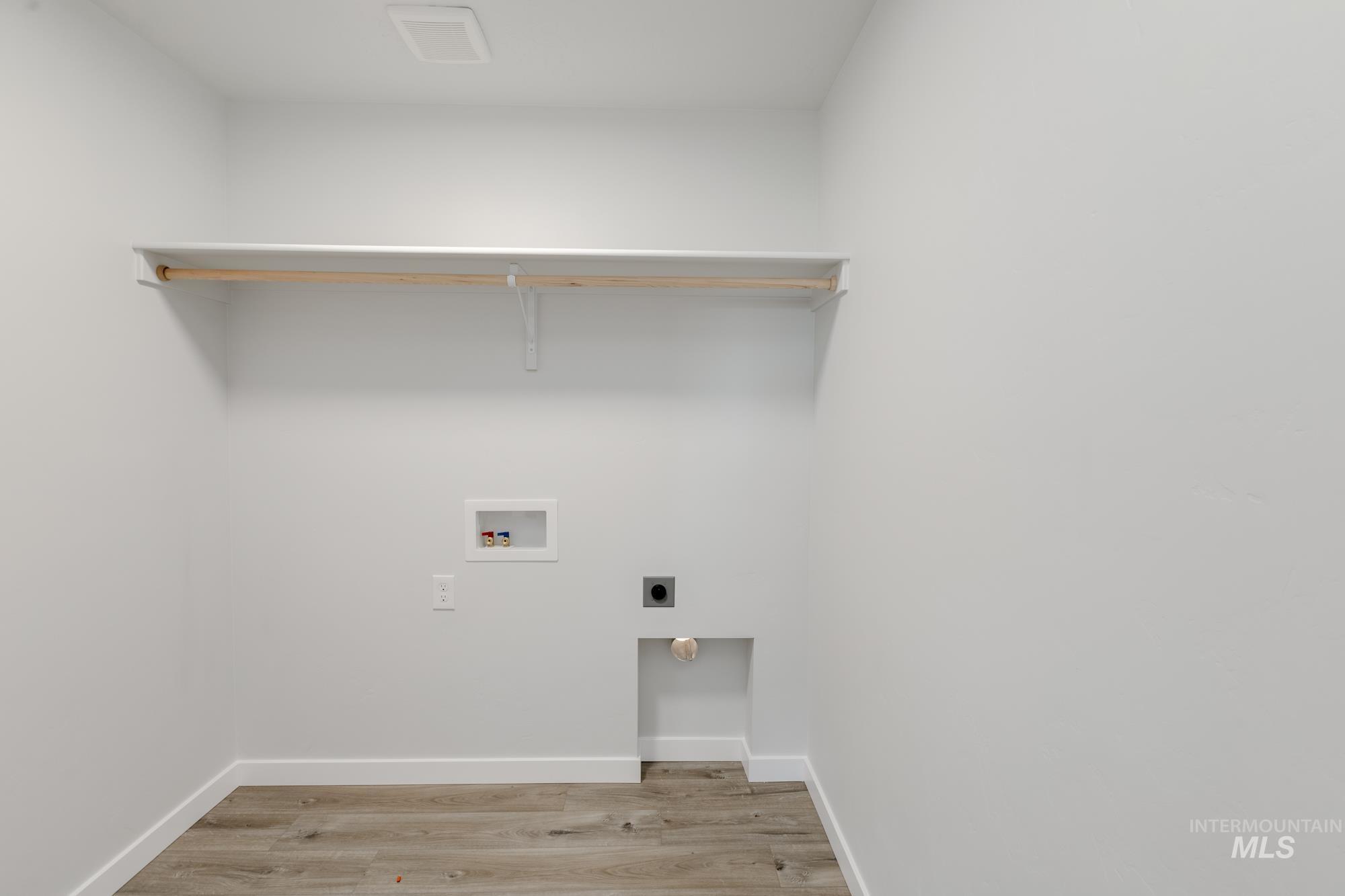 Laundry room with hookup for a washing machine, light wood-style flooring, and hookup for an electric dryer