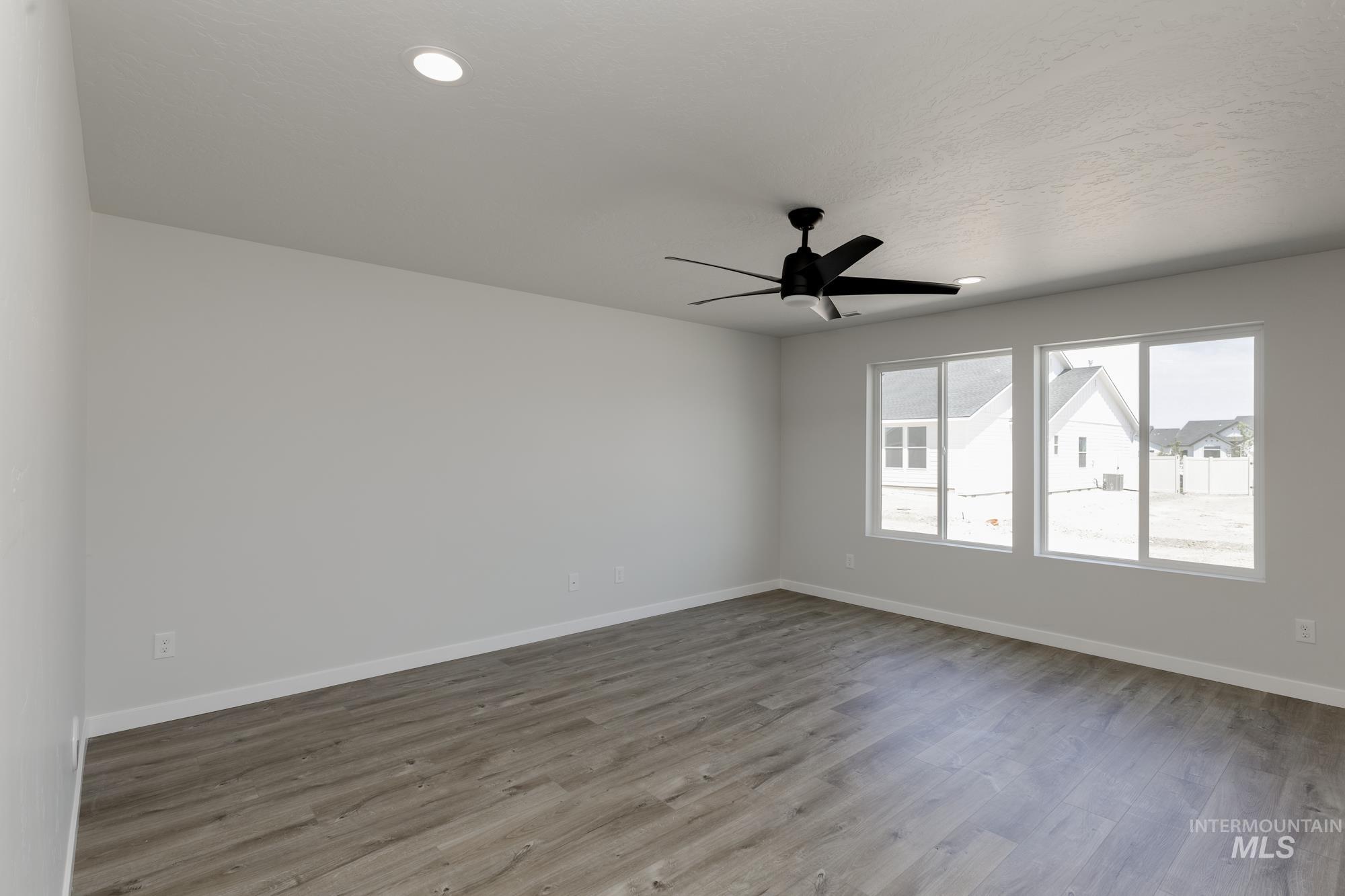 Empty room featuring wood finished floors, ceiling fan, and recessed lighting