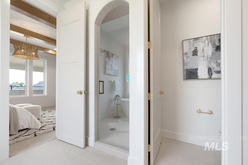 Bathroom with a soaking tub, a shower stall, light tile patterned flooring, and beamed ceiling