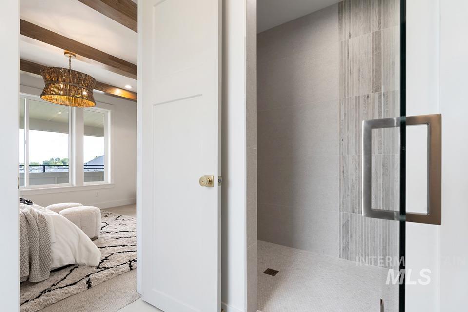 Bathroom featuring a walk in shower, beam ceiling, and a chandelier