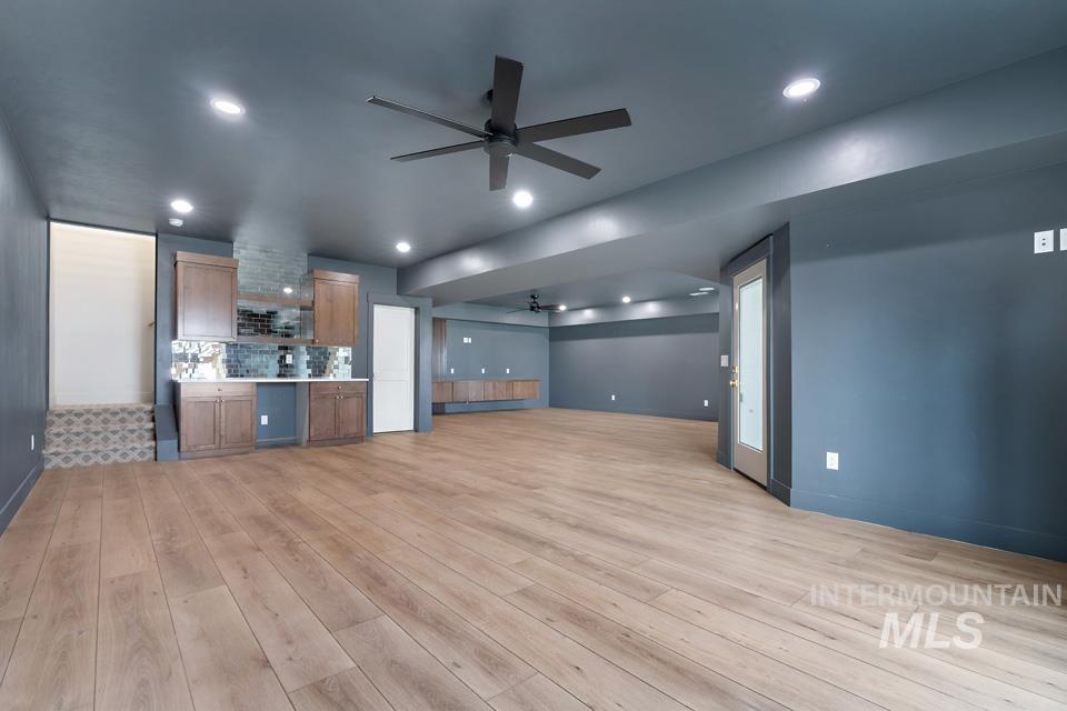 Unfurnished living room featuring ceiling fan, light wood-style floors, and recessed lighting