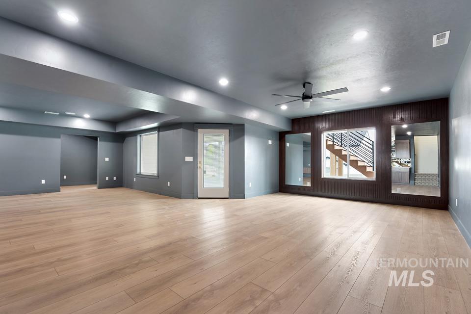 Home theater room with light wood-style floors, ceiling fan, and recessed lighting