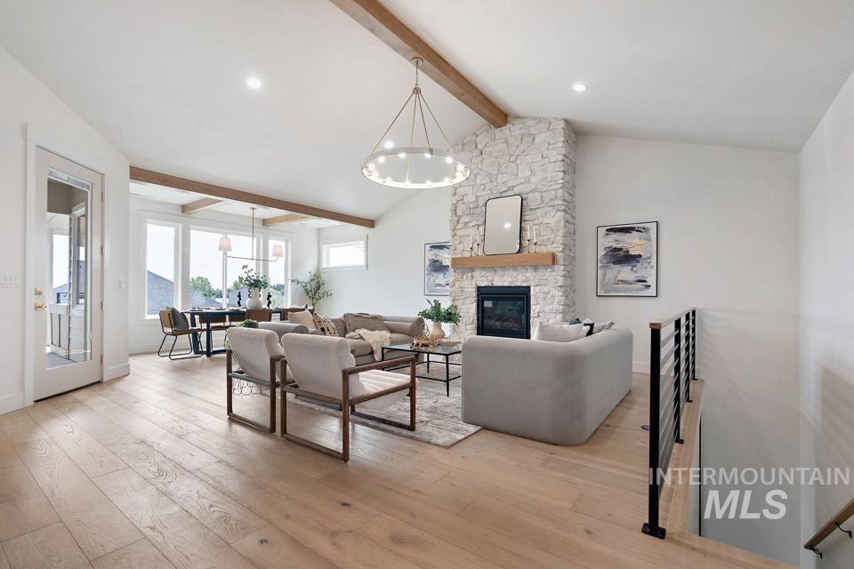 Living room with beamed ceiling, light wood-type flooring, a fireplace, high vaulted ceiling, and recessed lighting