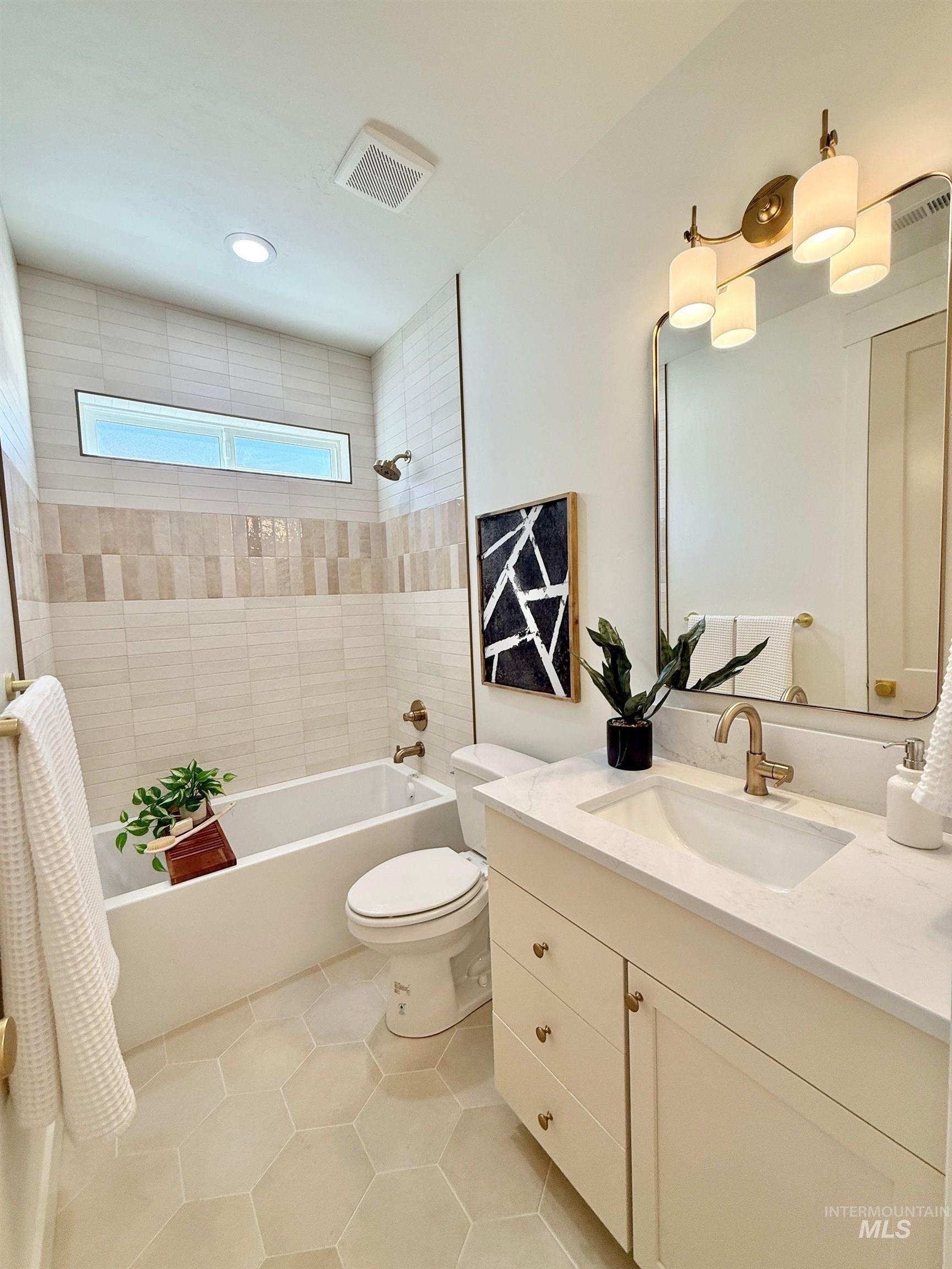 Full bathroom with tub / shower combination, vanity, and light tile patterned floors