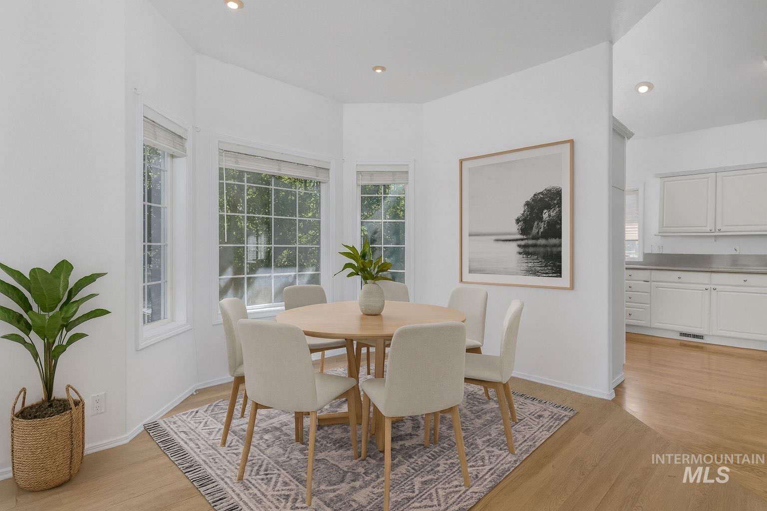 Dining area with recessed lighting and light wood-type flooring