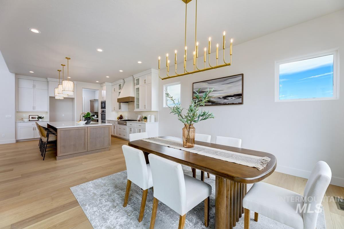 Dining space featuring light wood finished floors, a chandelier, recessed lighting, and healthy amount of natural light
