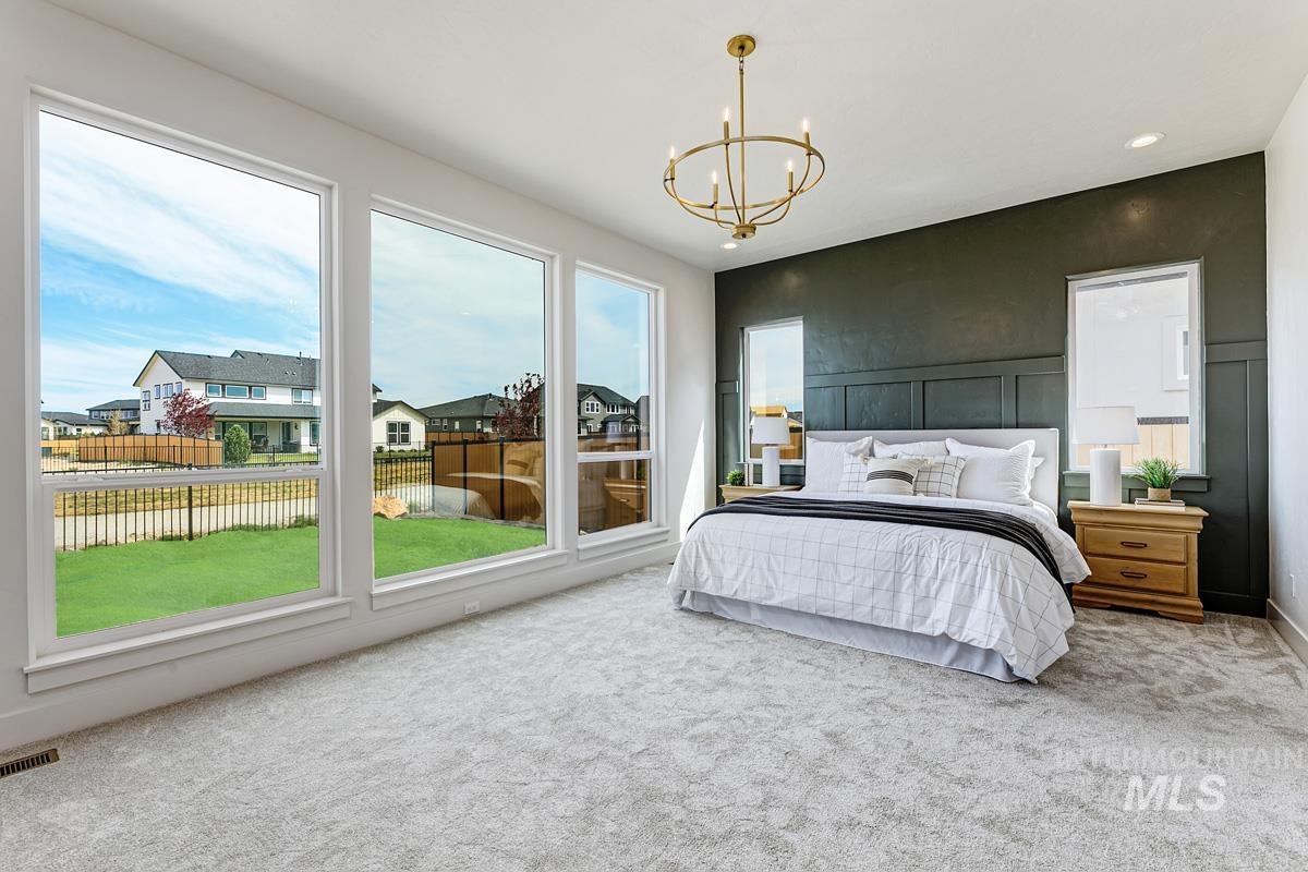 Carpeted bedroom with a chandelier, a residential view, and recessed lighting