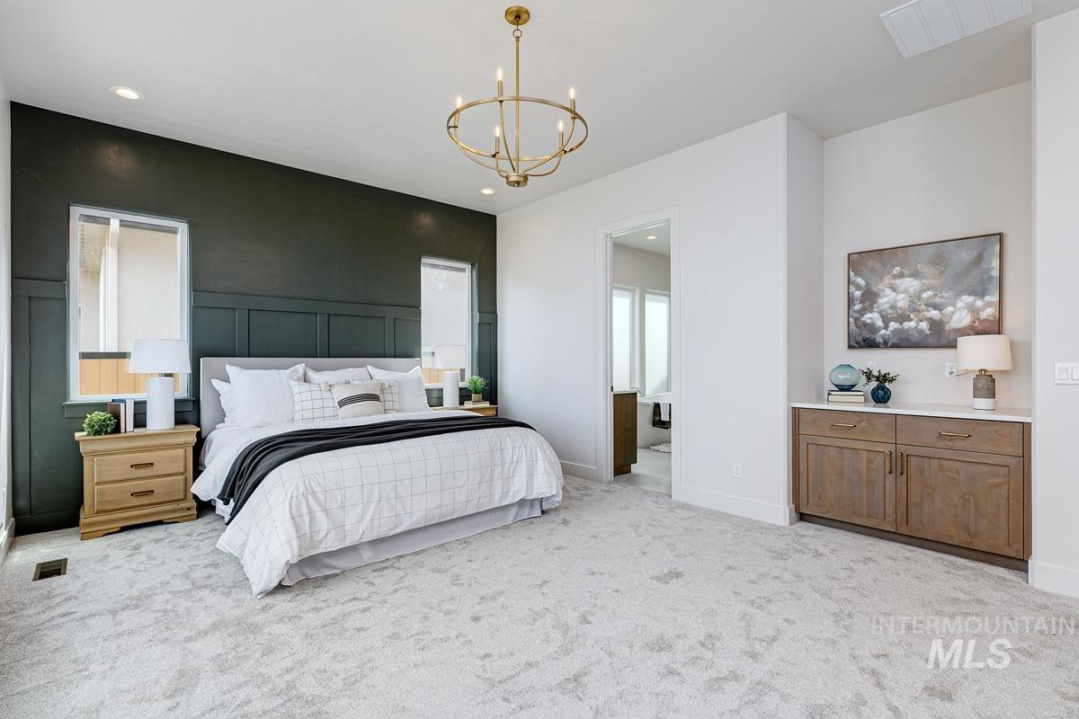 Bedroom featuring a chandelier, light colored carpet, and recessed lighting