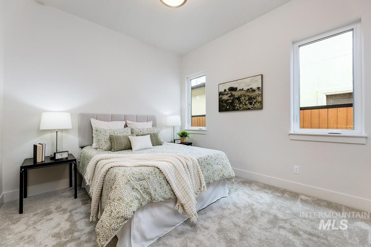 Bedroom featuring light colored carpet and baseboards