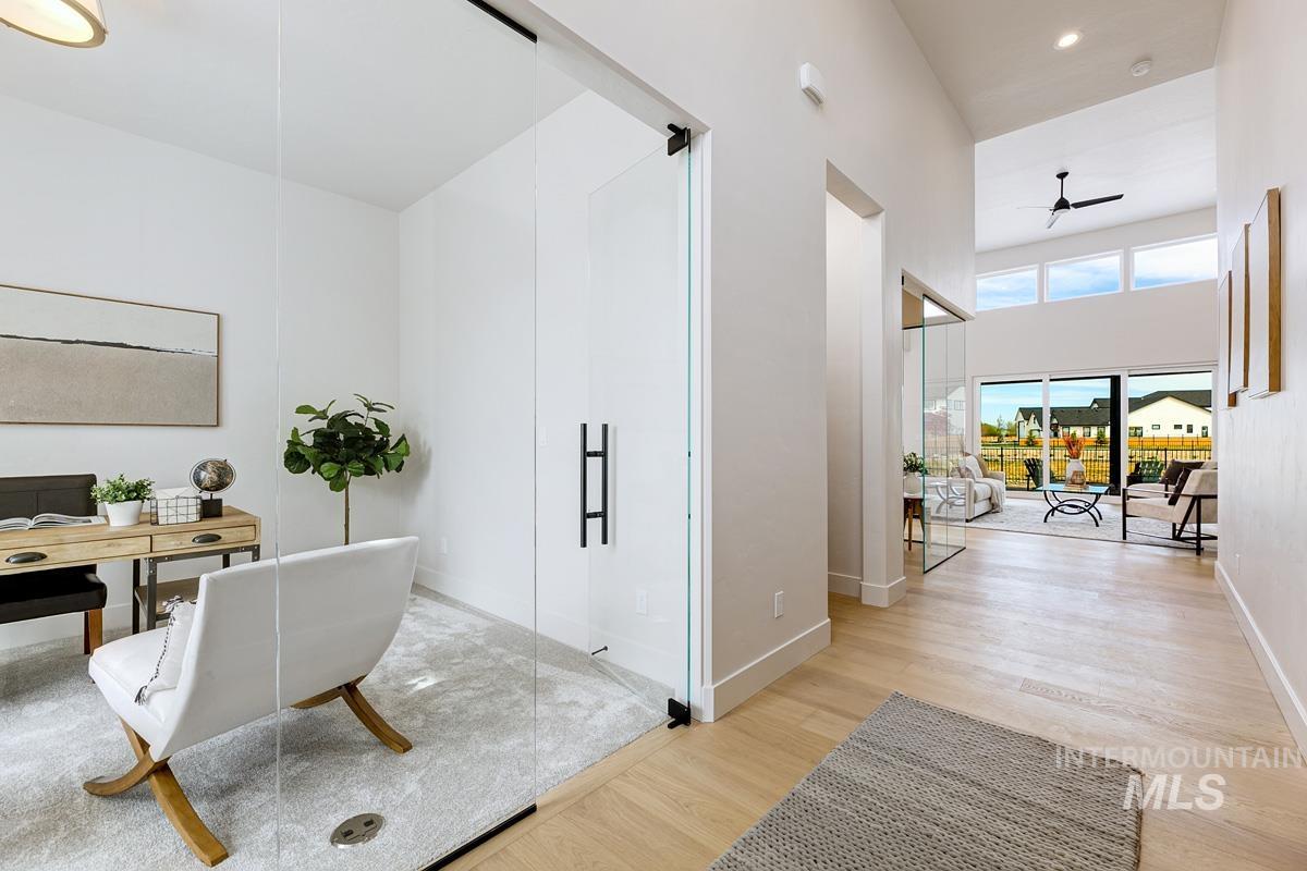 Office featuring light wood-style flooring, ceiling fan, a towering ceiling, and recessed lighting