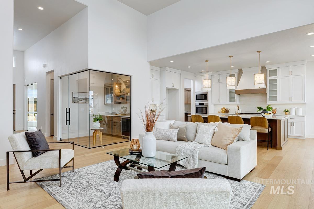 Living area featuring recessed lighting, light wood-style floors, a high ceiling, and beverage cooler