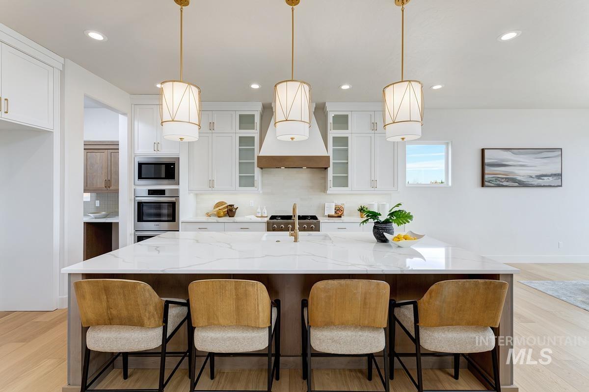Kitchen featuring tasteful backsplash, light wood finished floors, white cabinets, and recessed lighting