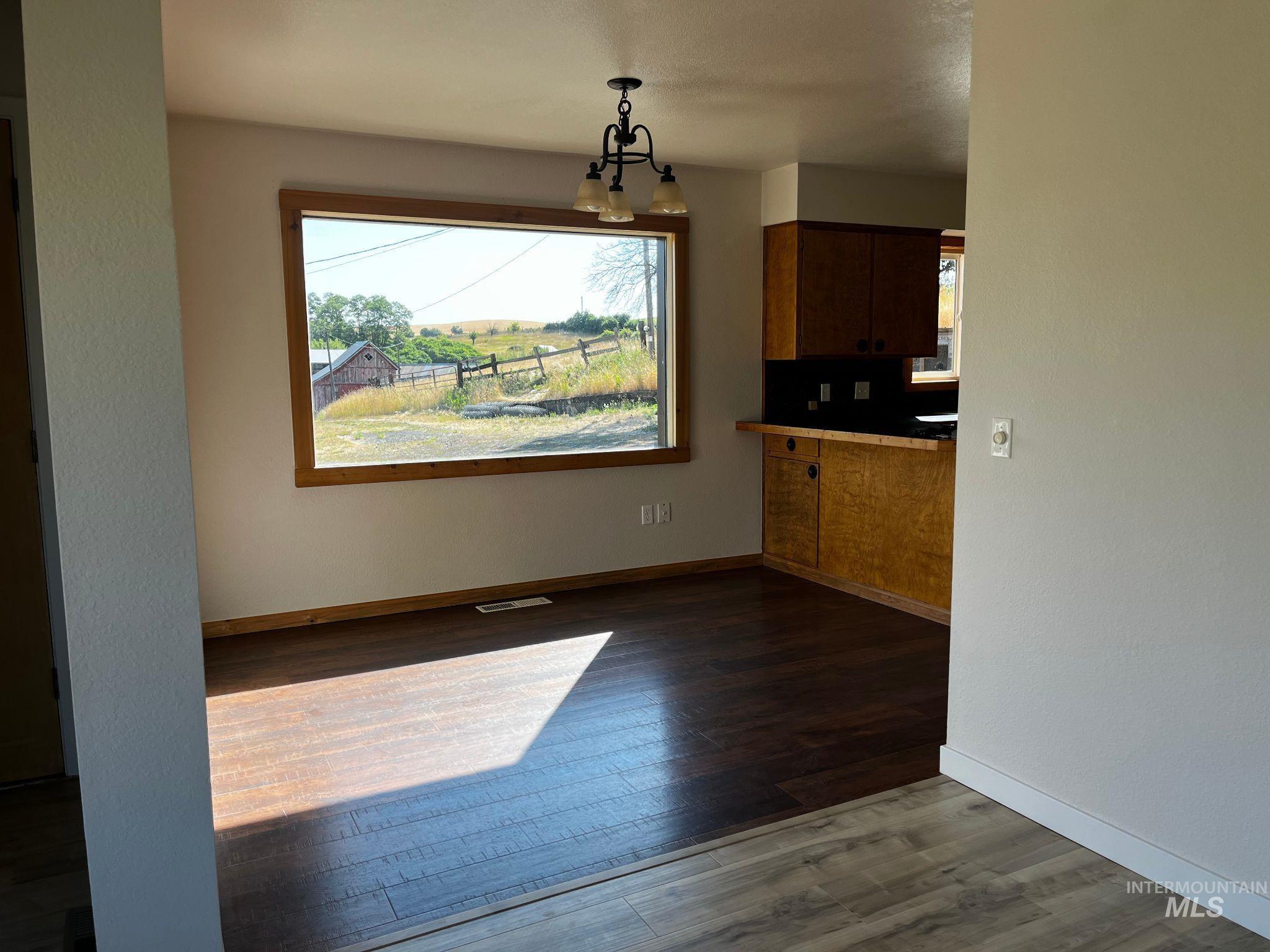 Unfurnished dining area with dark wood-style floors
