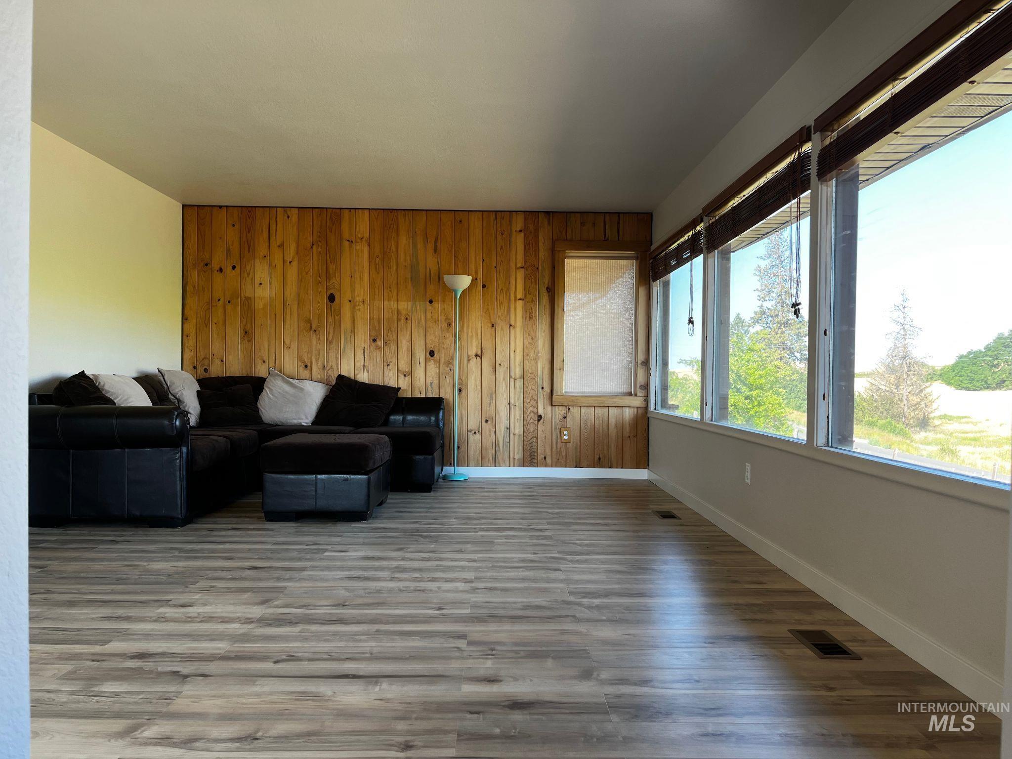 Living area with wood finished floors and wood walls