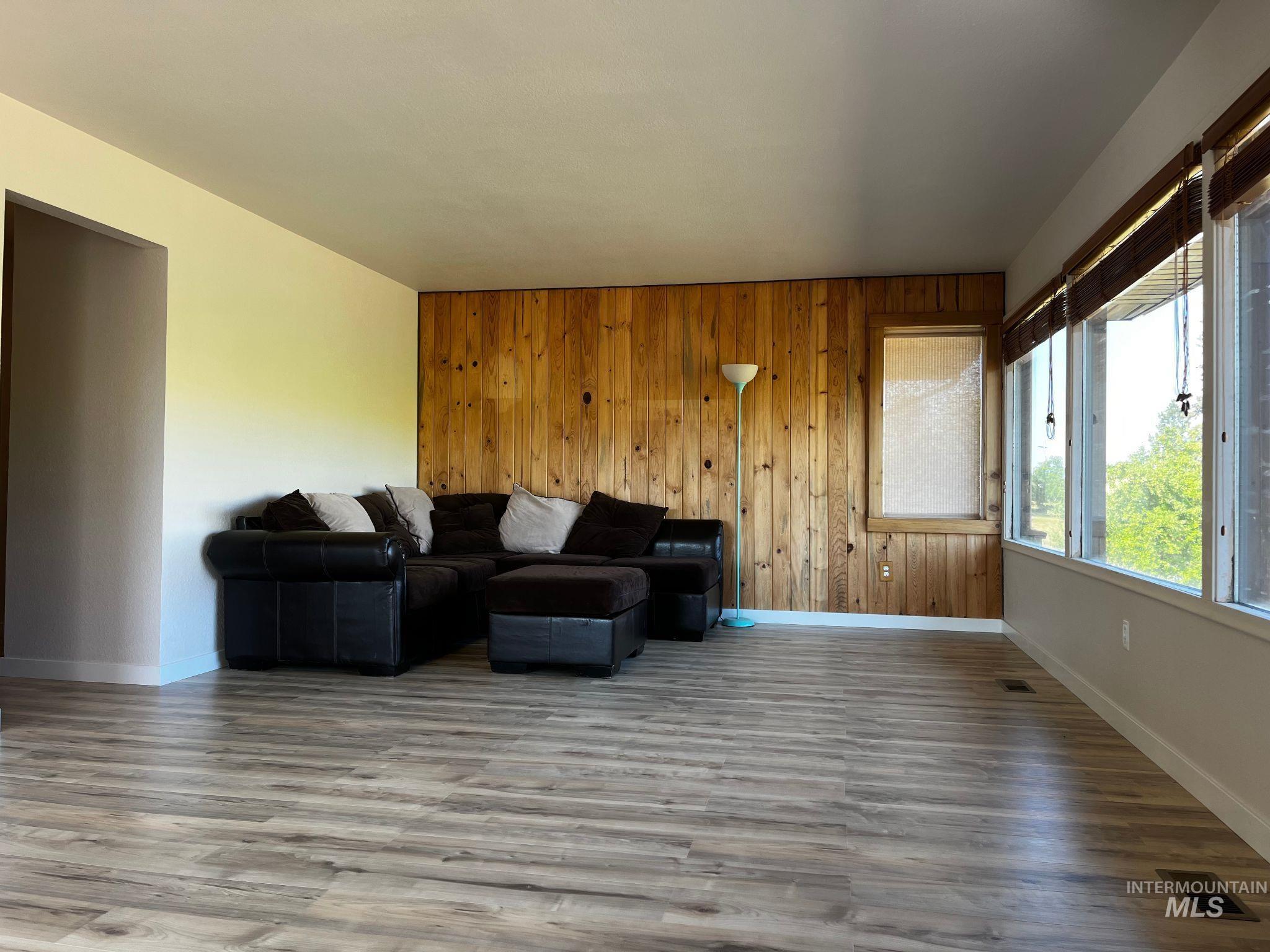 Living room with wood finished floors and wood walls