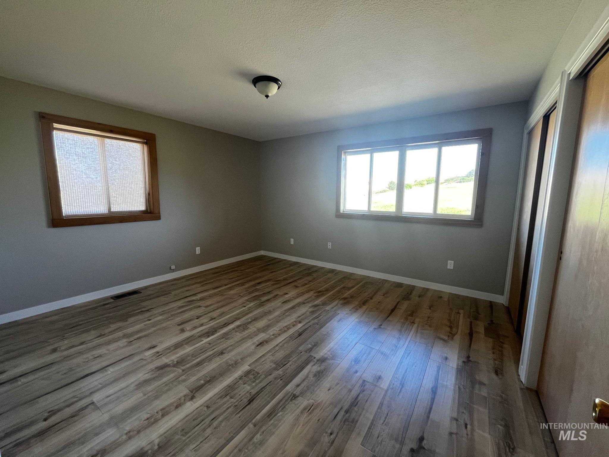 Spare room featuring wood finished floors and a textured ceiling