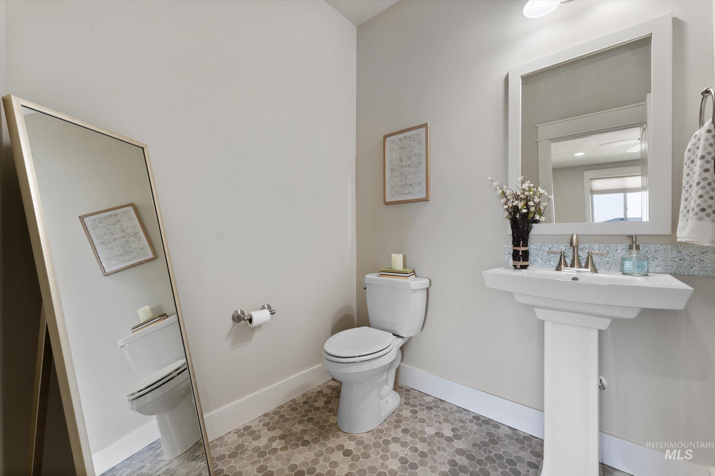 Half bath with toilet and light tile patterned flooring