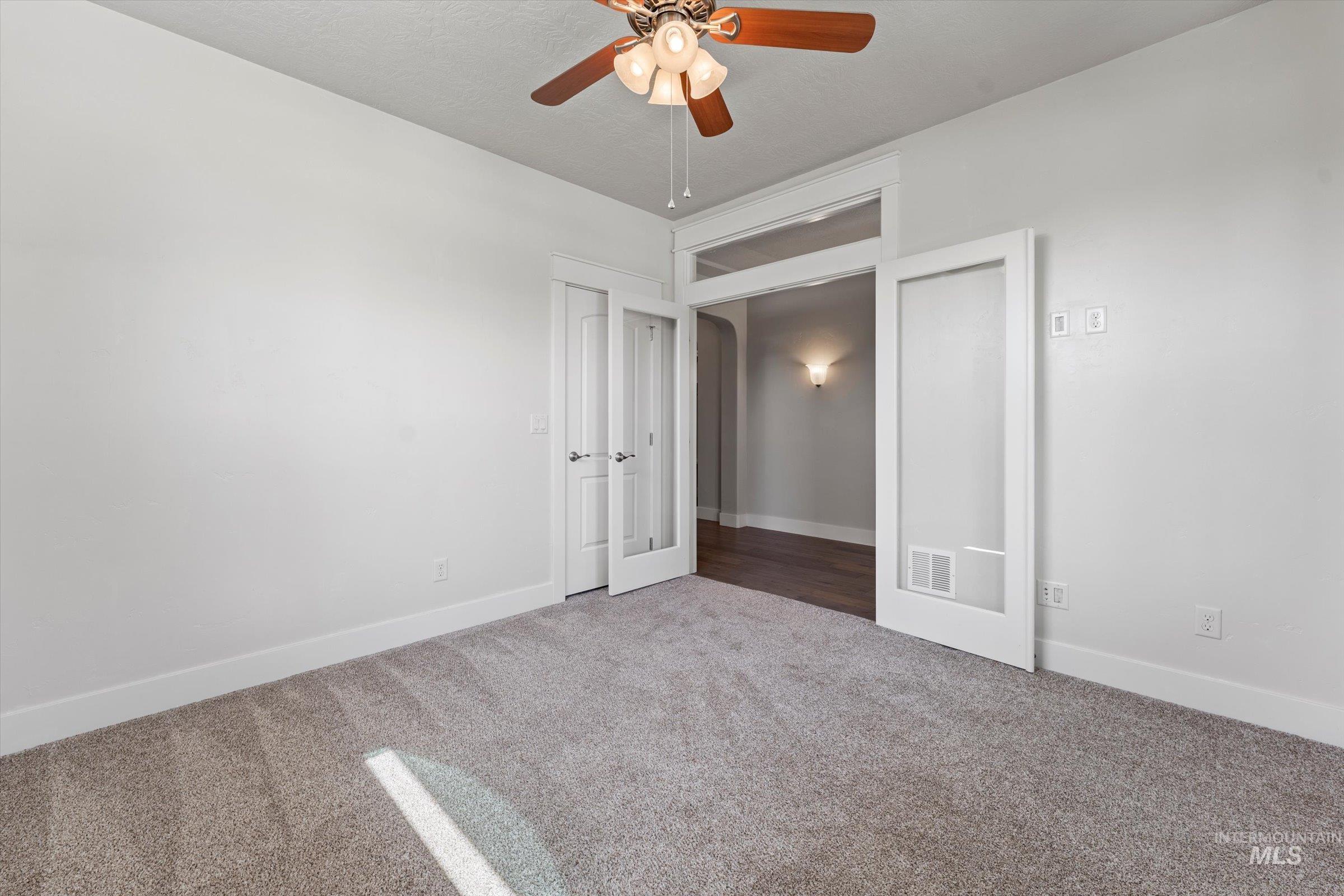 Unfurnished bedroom featuring carpet floors and ceiling fan