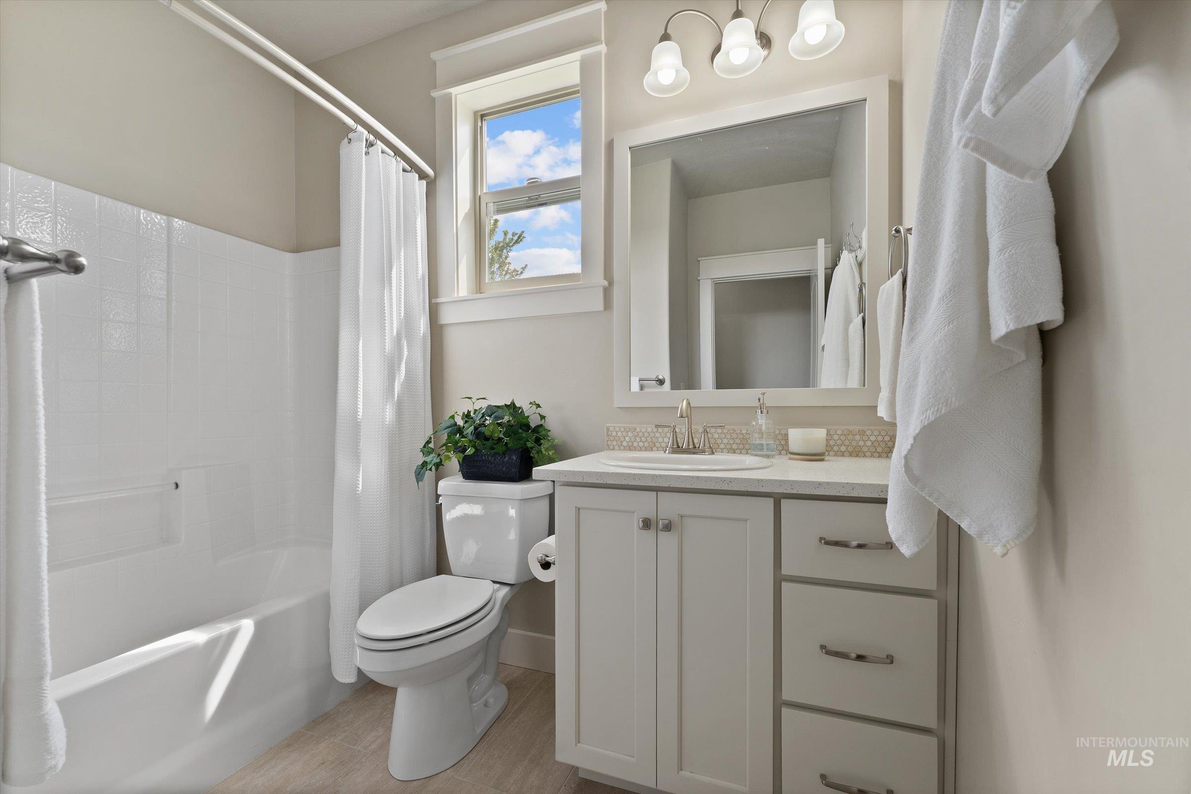 Bathroom with shower / bath combo with shower curtain and vanity