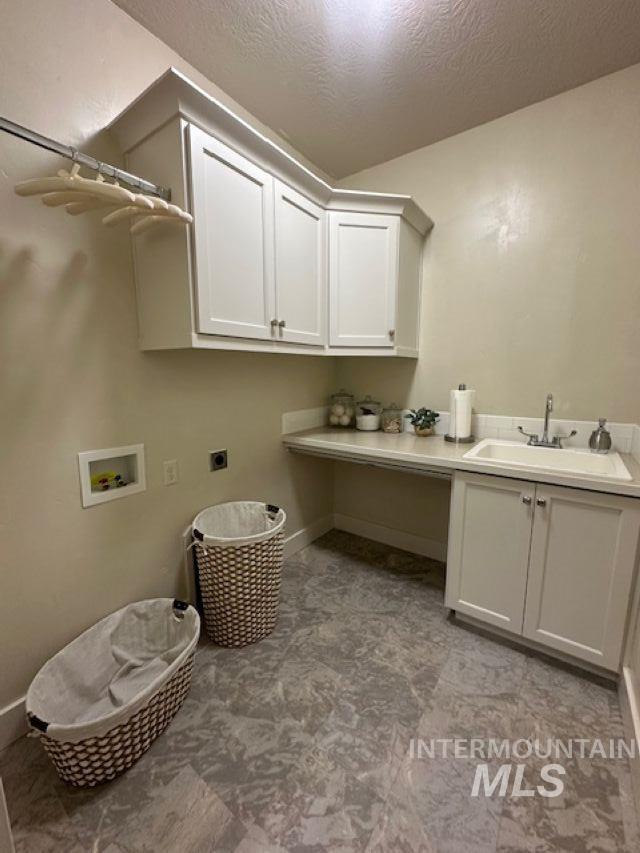 Laundry room with a textured ceiling, hookup for a washing machine, cabinet space, and electric dryer hookup