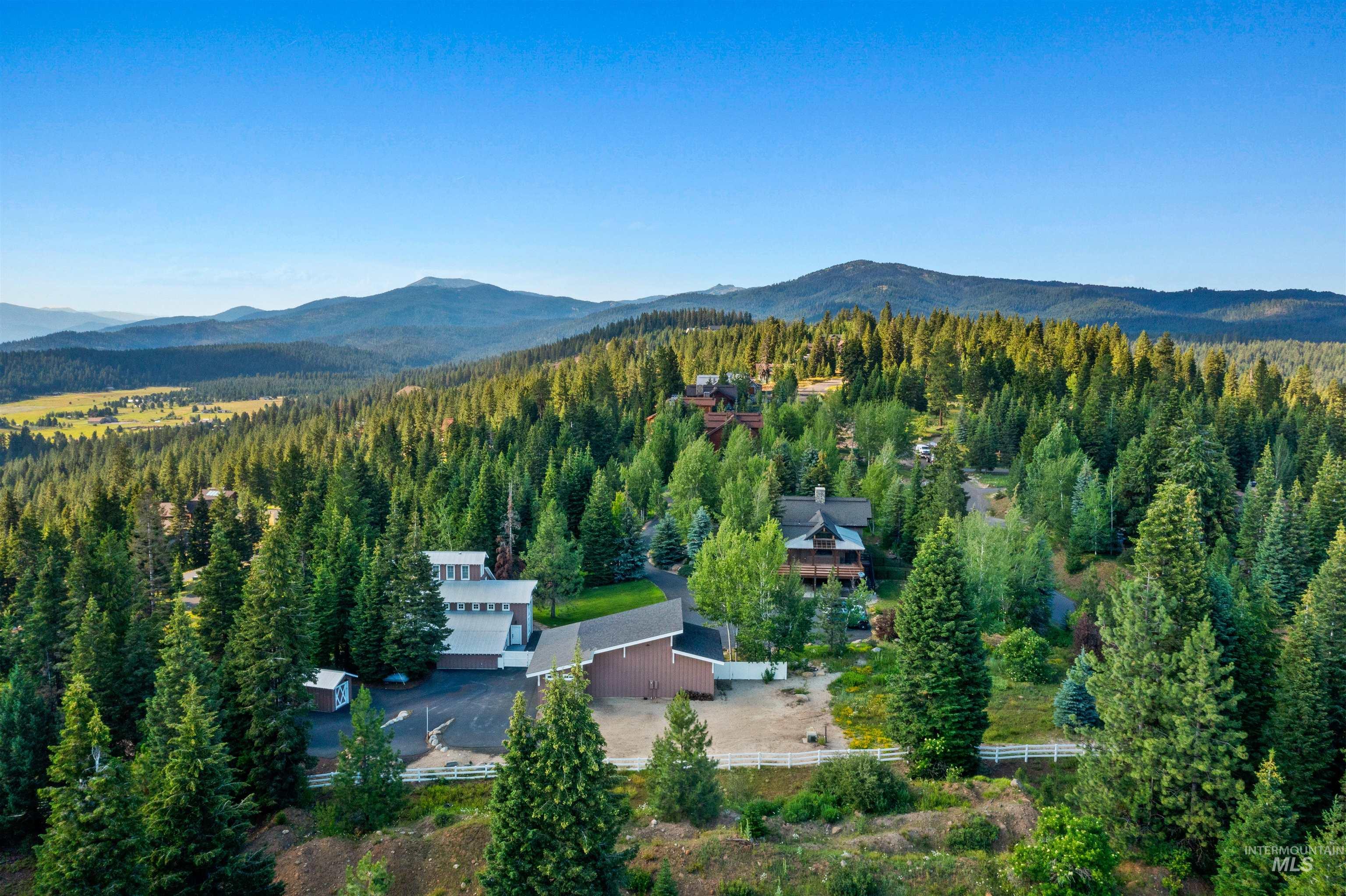 Aerial view of property and surrounding area featuring a mountainous background