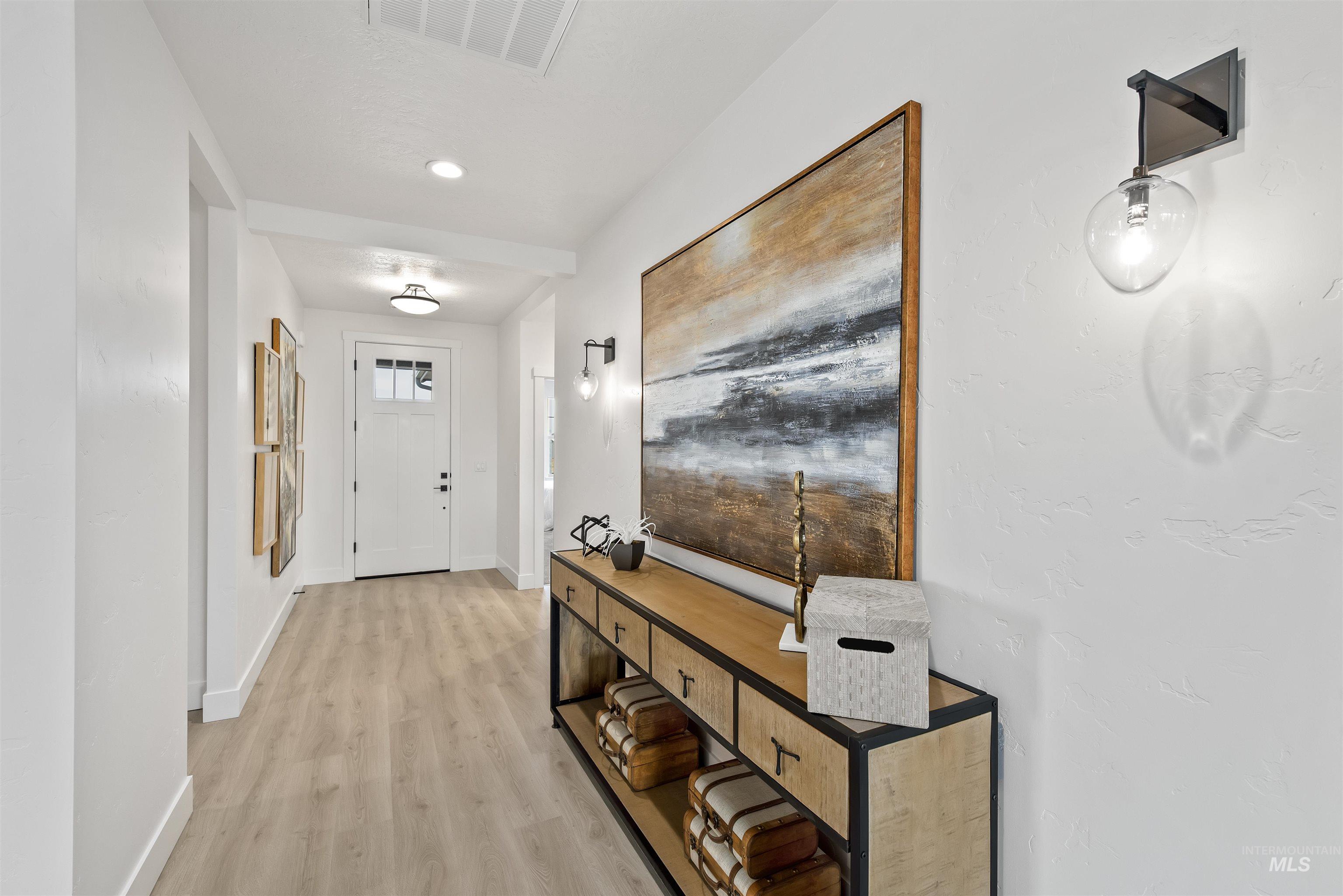 Doorway to outside featuring wood finished floors and baseboards