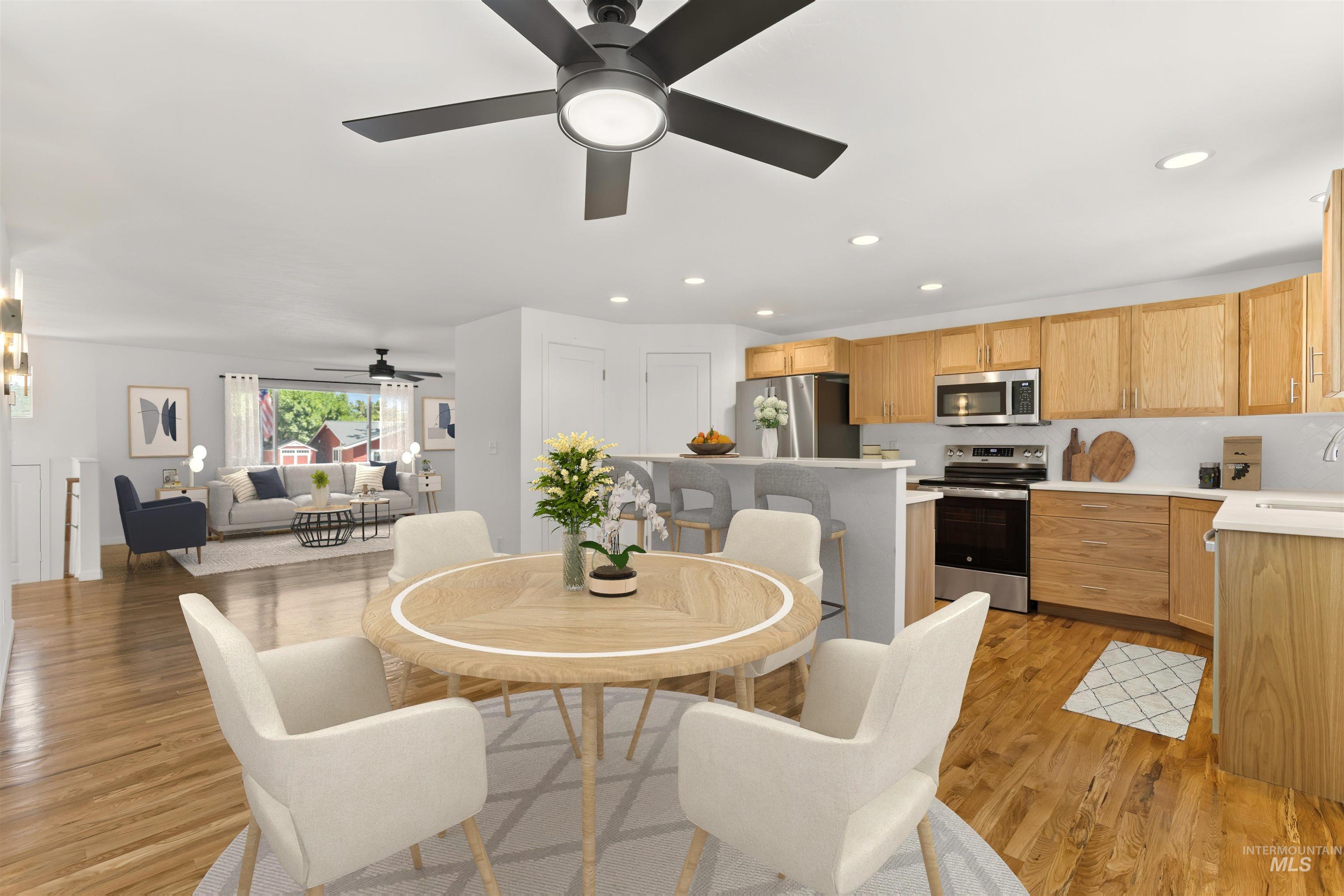 Dining space with a ceiling fan, light wood-style floors, and recessed lighting