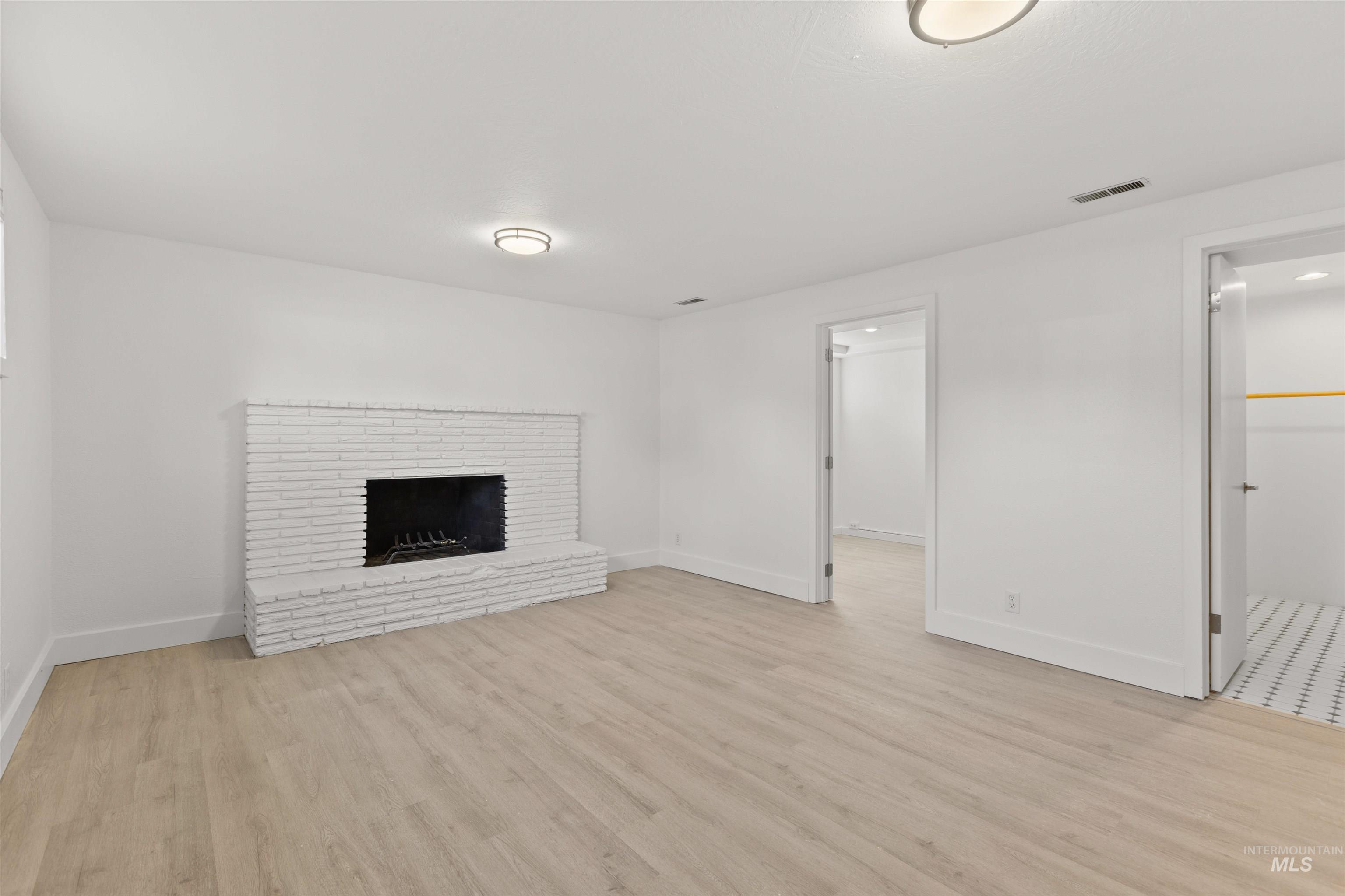 Unfurnished living room with light wood finished floors and a fireplace