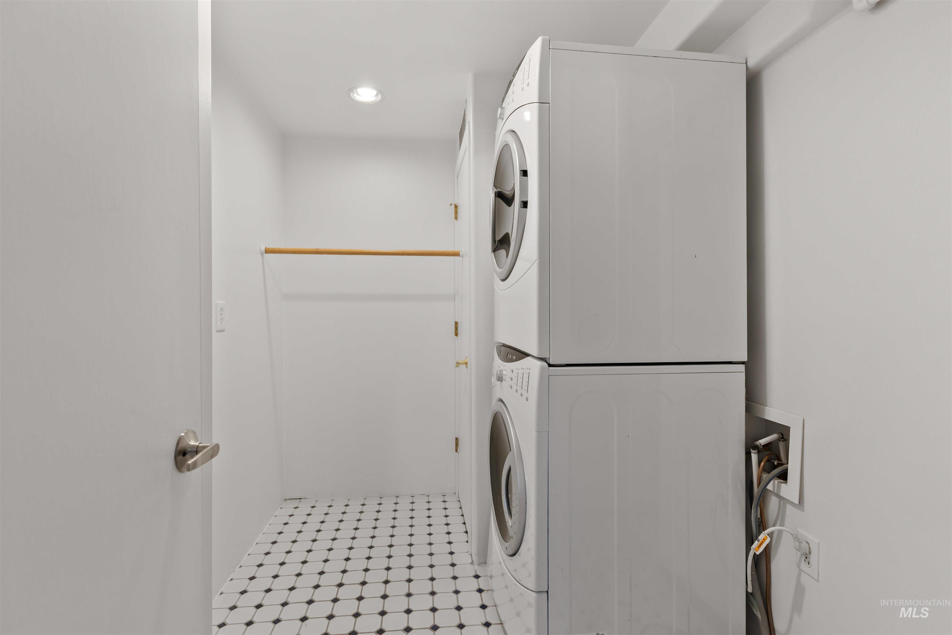 Laundry area with estacked washer and dryer and recessed lighting